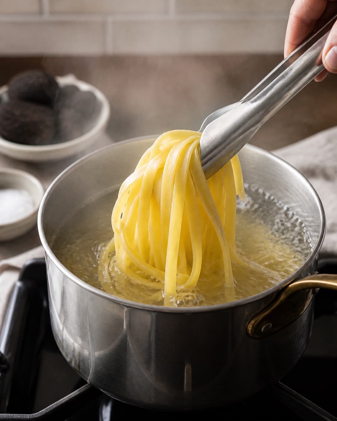 Long tagliatelle ribbons boiling freely in one pot of salted water, still firm, no sauce truffle or plated pasta under tilberedningen af pasta med trøffel