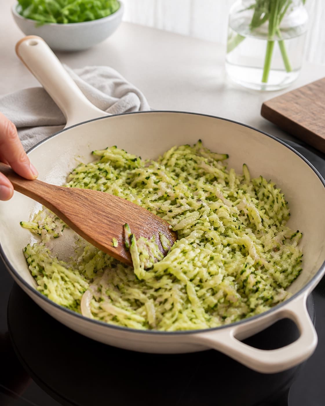Grated zucchini and translucent shallot sautéing dry in one ovenproof skillet, no eggs cheese herbs or finished frittata under tilberedningen af frittata med squash