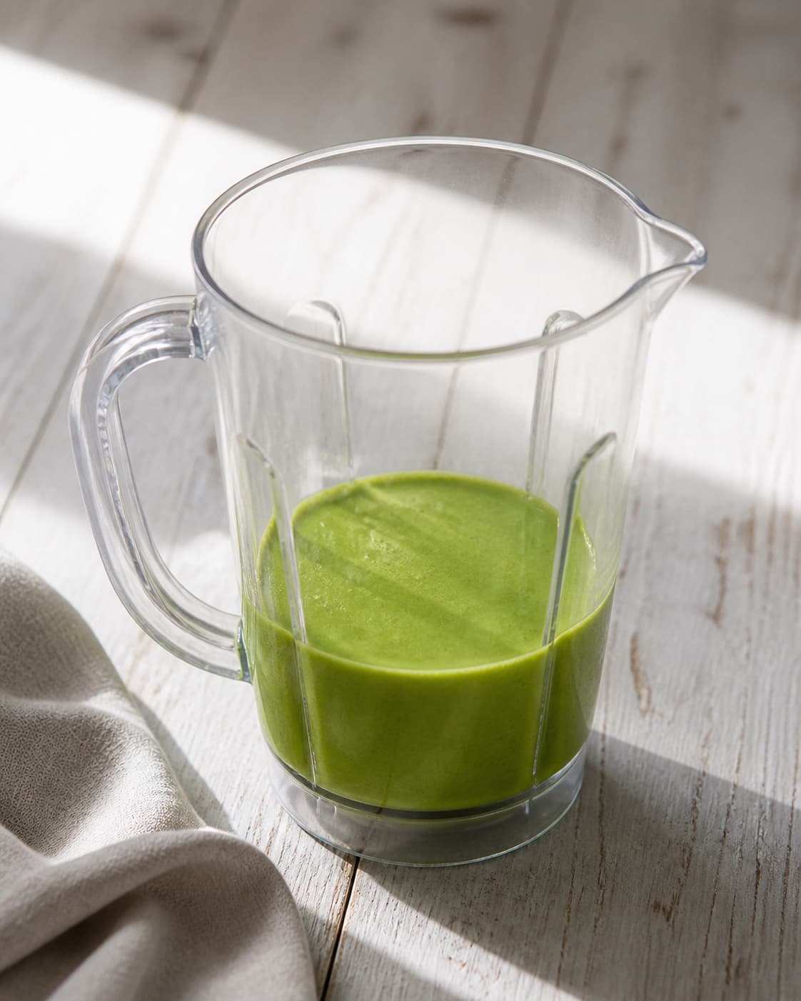 One blender jug holding uniformly vivid-green fluid waffle batter with no visible kale pieces, no butter waffle iron roe cream onion or dill under tilberedningen af grønkålsvafler med stenbiderrogn