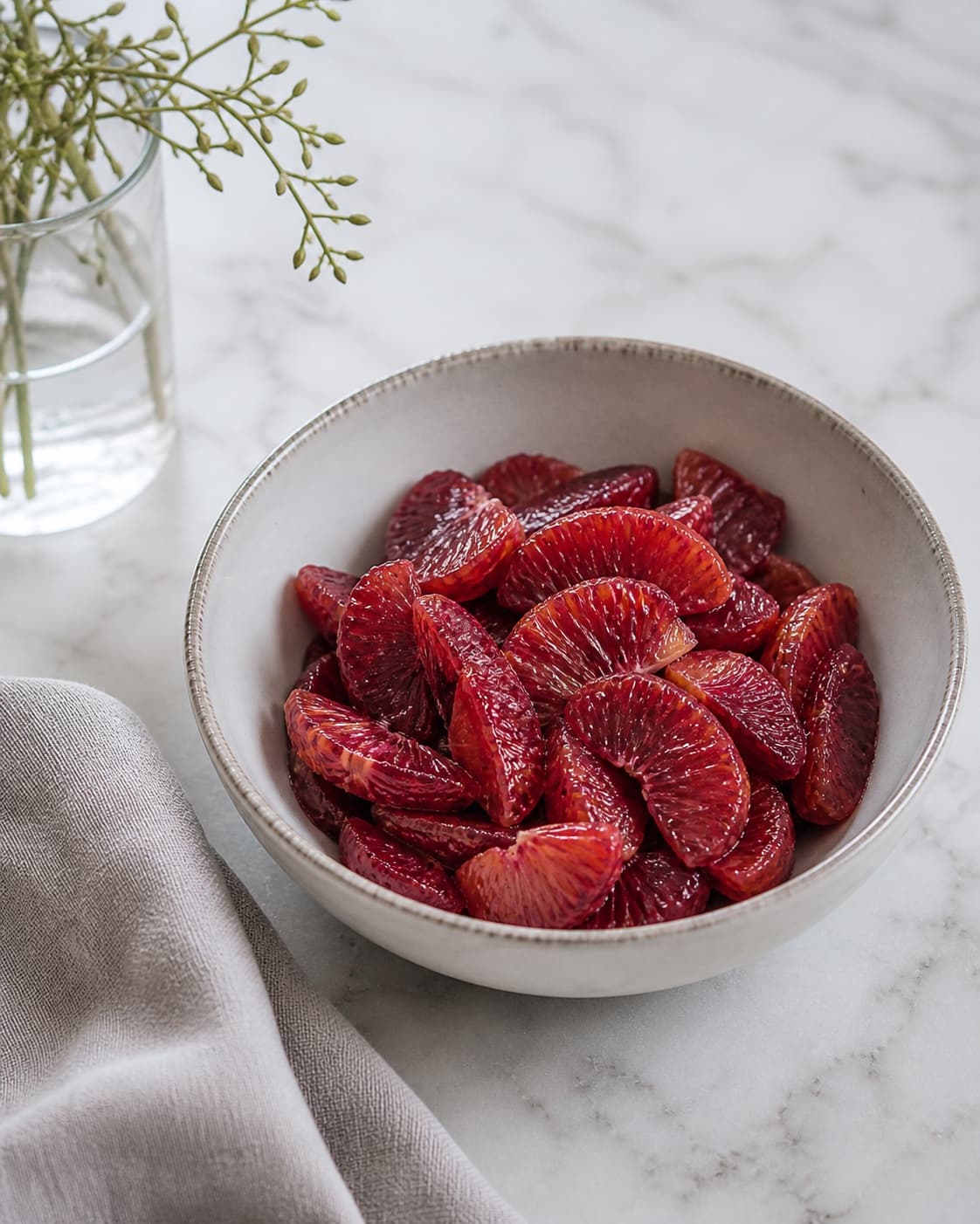 Ruby-red citrus segments cut from exactly three blood oranges collected in one bowl, no peel, greens, nuts, dressing or extra fruit under tilberedningen af blodappelsinsalat med rucola
