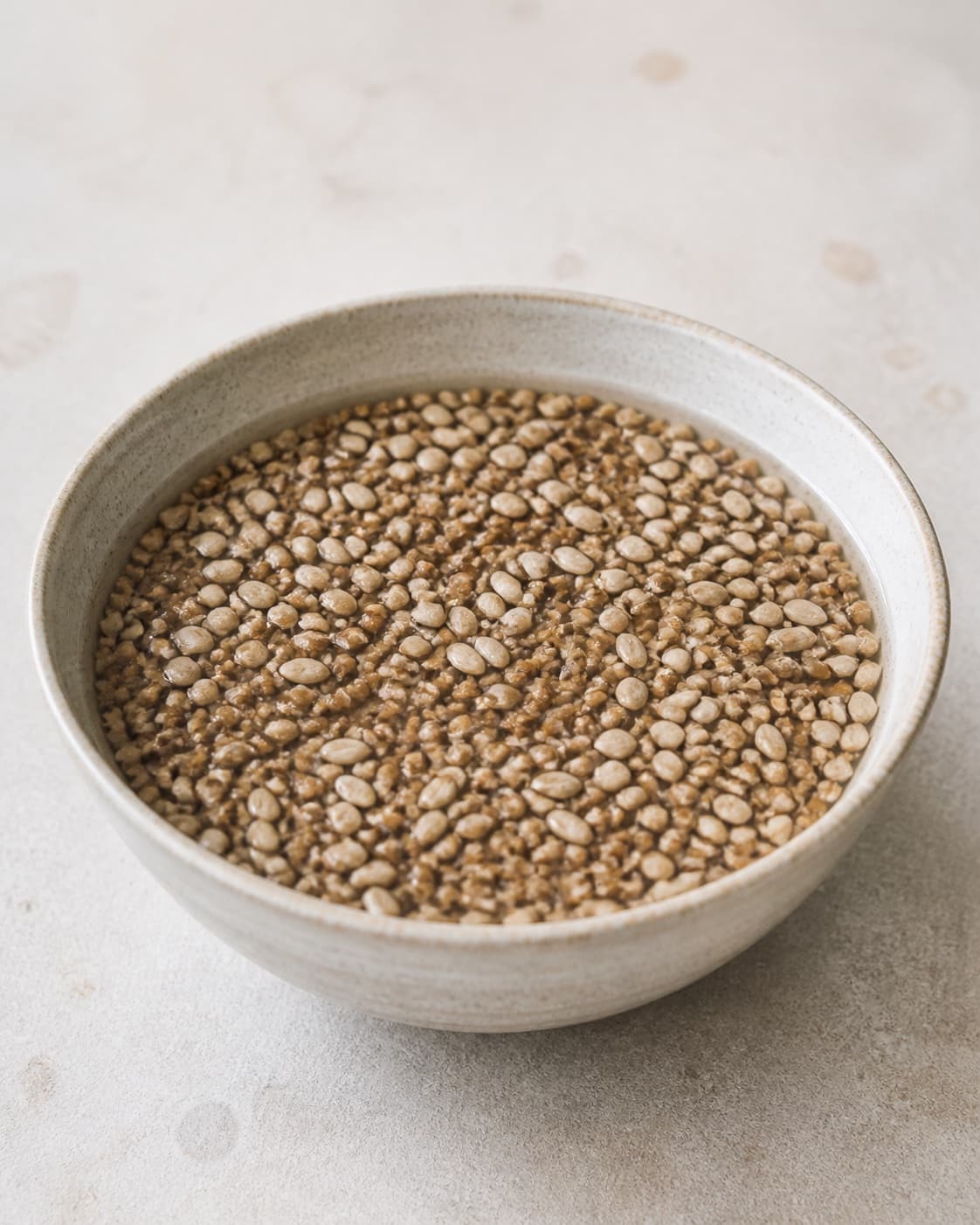One large bowl containing cracked rye kernels and sunflower seeds soaking in hot water, no flour chocolate beer dairy dates or dough under tilberedningen af chokorug