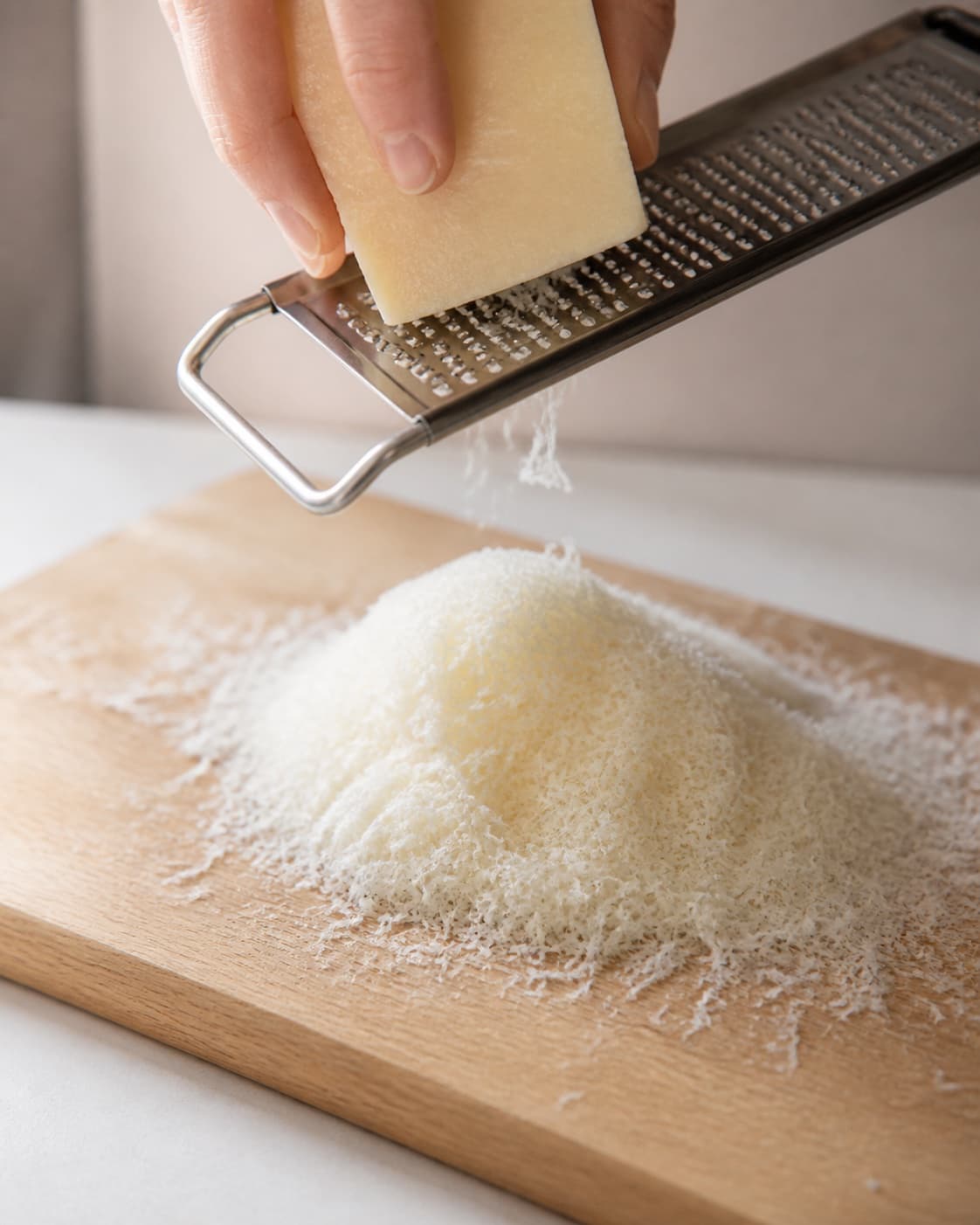One airy pile of finely freshly grated Parmesan on one board, no herbs pepper baking tray or chips under tilberedningen af parmesanchips med krydderurter