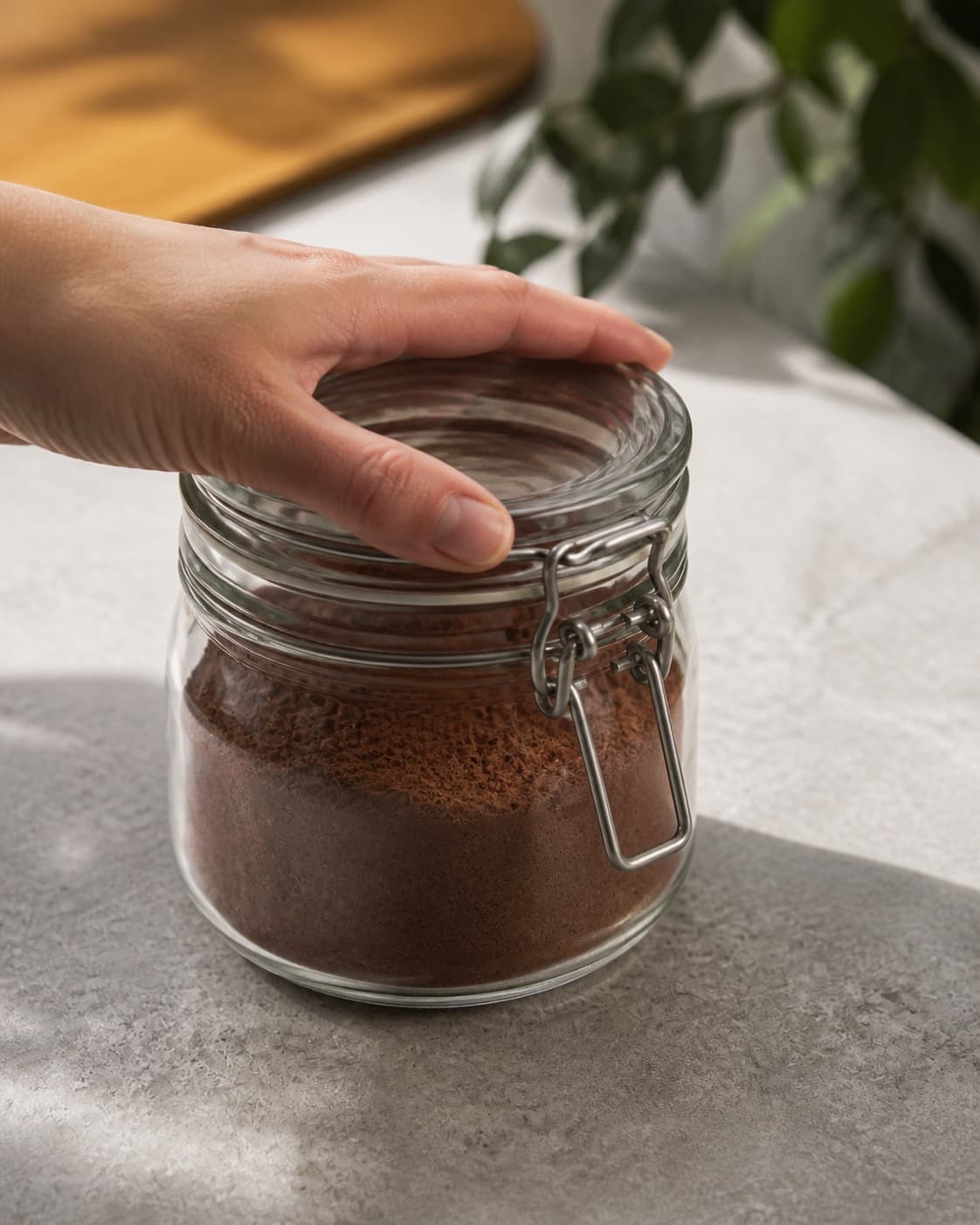 One single closed airtight glass jar filled with dark homemade cocoa mix, no mug milk spoon or extra jars under tilberedningen af kakaopulver til varm kakaomælk