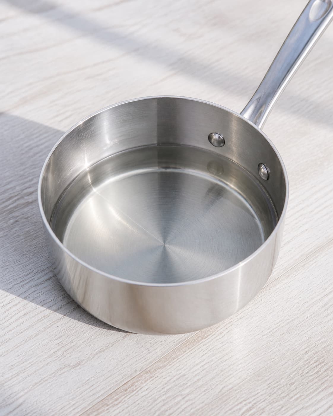 One small saucepan holding completely clear freshly dissolved simple syrup, no lime alcohol ice glass or bottle under tilberedningen af caipirinha cocktail