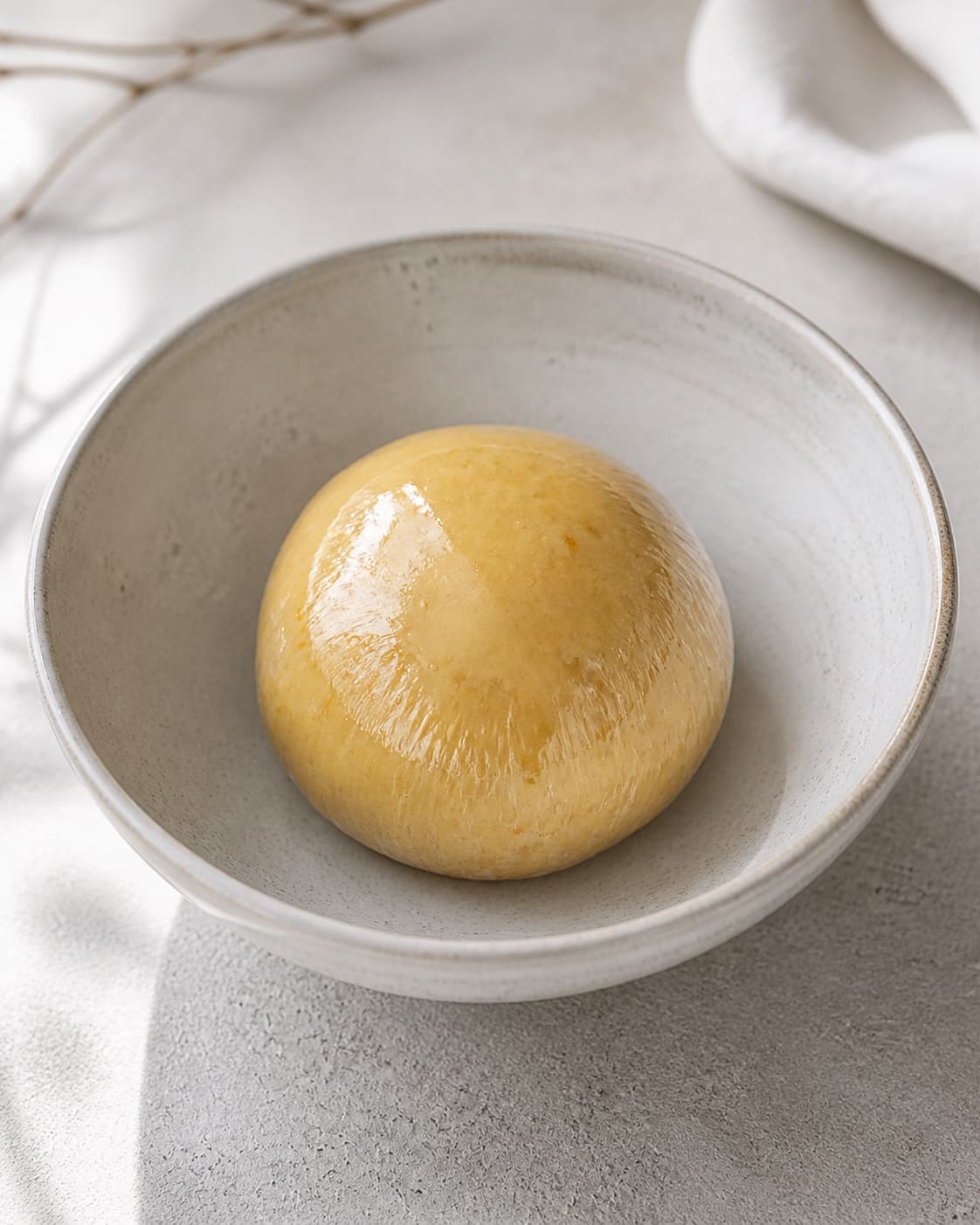 One bowl holding one smooth orange-zest-speckled pastry dough ball wrapped tightly and ready to chill, no rice custard forms or extra ingredients under tilberedningen af toscana ristærter