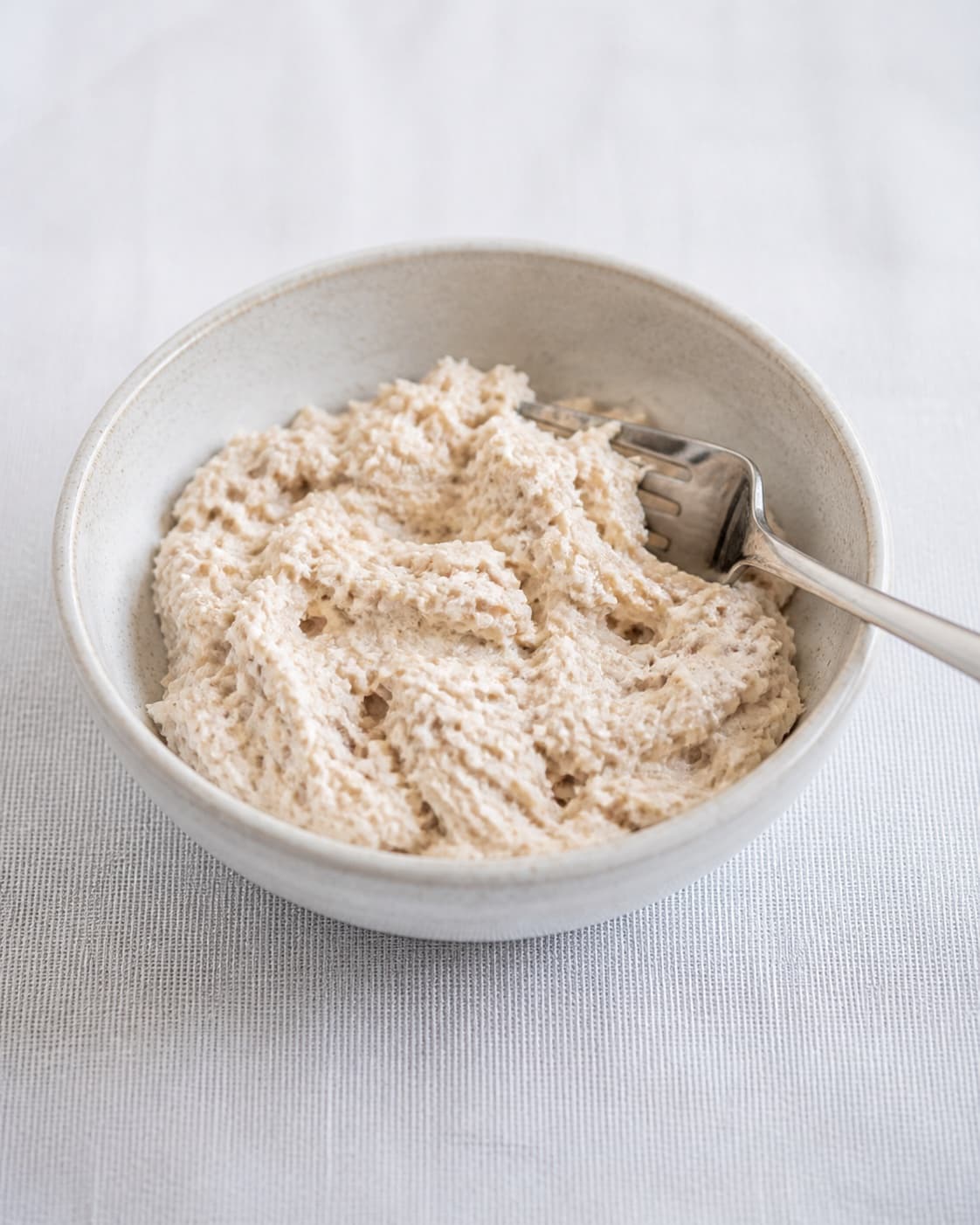 One bowl of pale creamy smoked mackerel rillettes with small visible fish flakes, no chives lemon bread radish or garnish under tilberedningen af makrelmousse - røget makrelrilette
