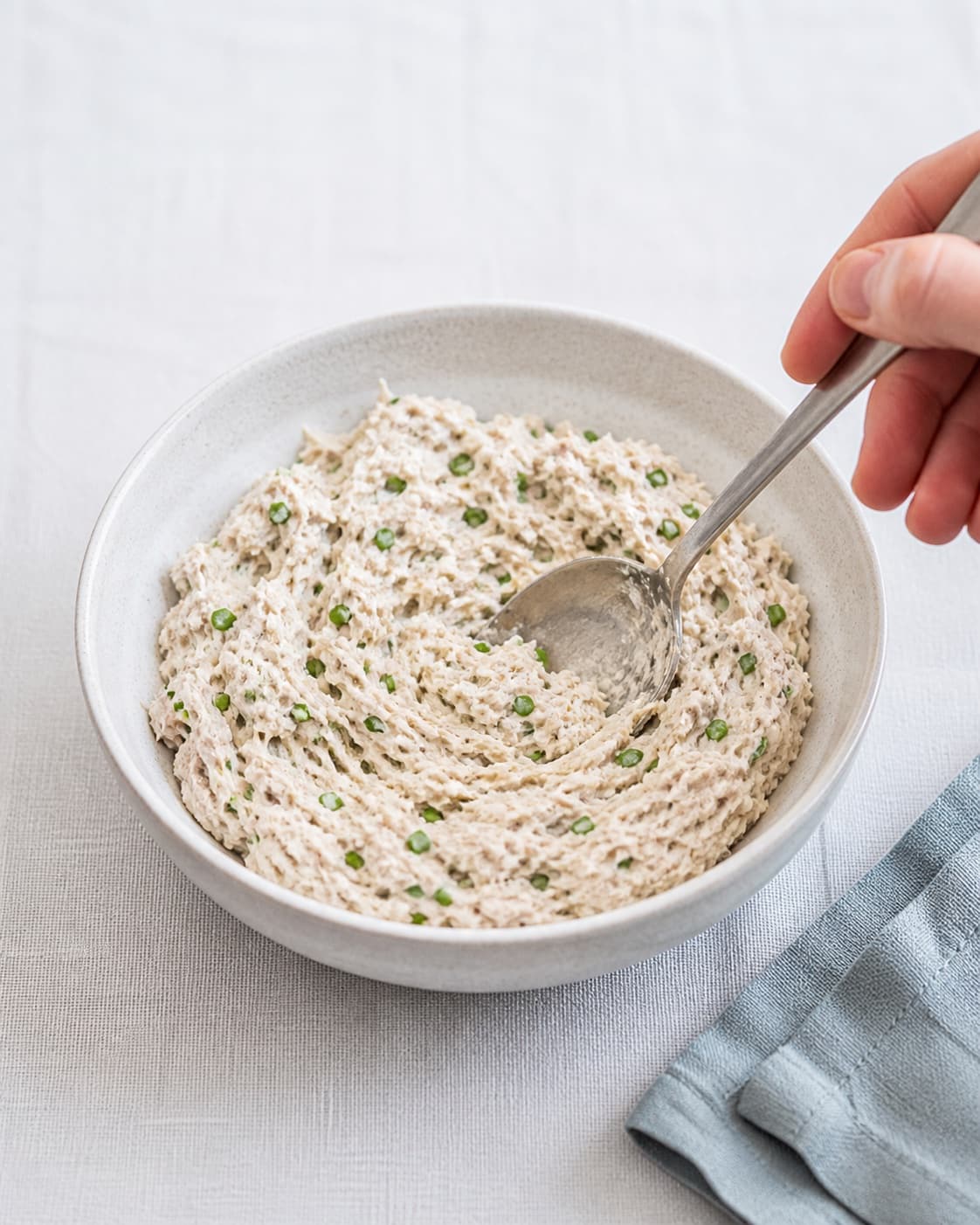 One bowl of creamy smoked mackerel rillettes evenly flecked with finely chopped green chives, no bread radish serving plate or garnish under tilberedningen af makrelmousse - røget makrelrilette