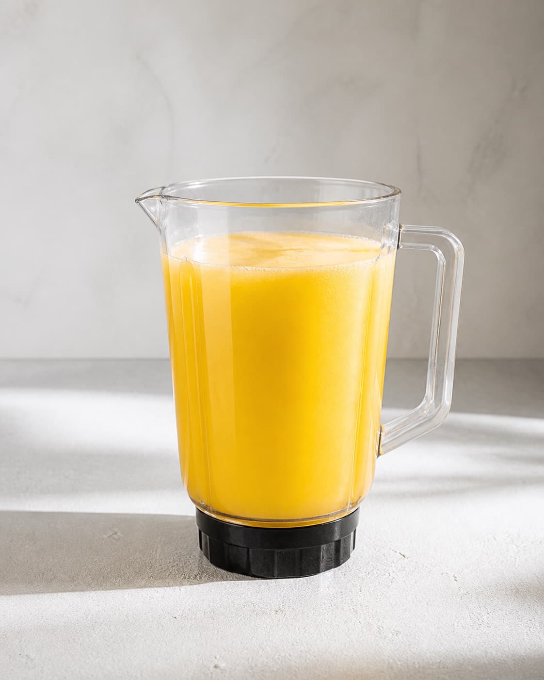One blender jug holding smooth vivid yellow pineapple-ginger juice, no rum mint ice glasses sparkling water or garnish under tilberedningen af ananasmojito med ingefær og mynte