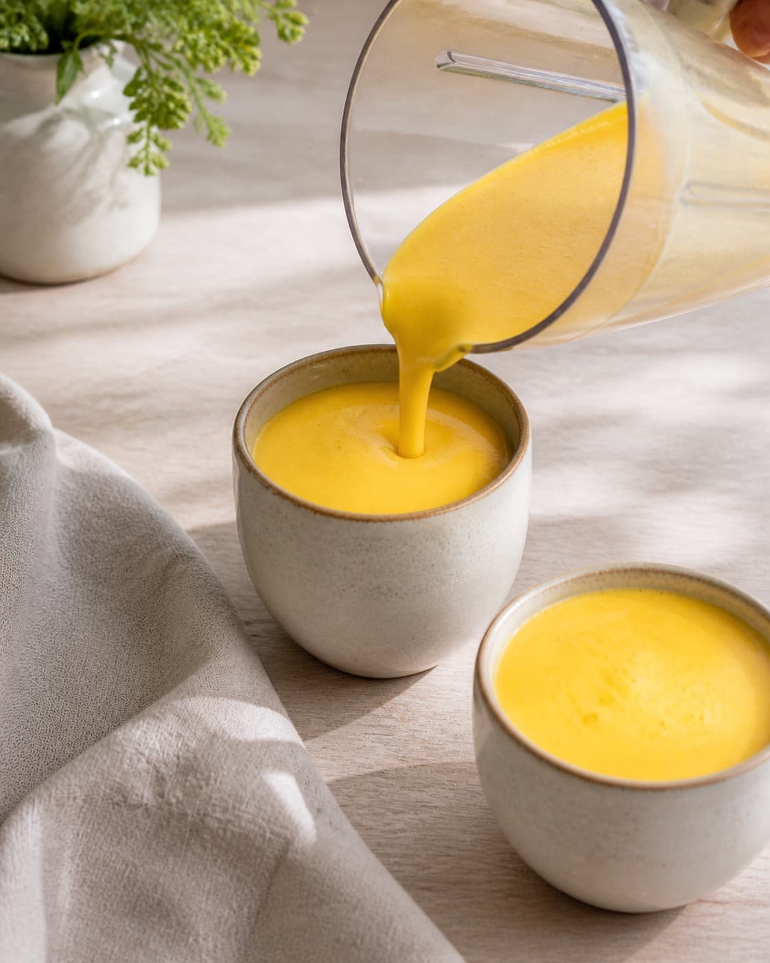 One single photorealistic instructional frame of the finished smoothie poured into clean chilled glasses or bowls for Mango Lassi, featuring mango, yoghurt naturel, mælk, with only the named equipment and no unrelated food, text, logos or packaging under tilberedningen af mango lassi