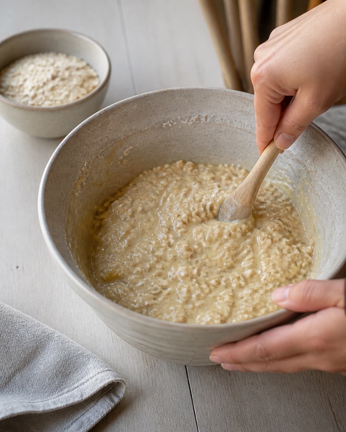 One single photorealistic instructional frame of the wet muffin mixture being combined in one bowl for Hverdagsmuffins uden sukker, featuring bananer, havregryn, æg, with only the named equipment and no unrelated food, text, logos or packaging under tilberedningen af hverdagsmuffins uden sukker