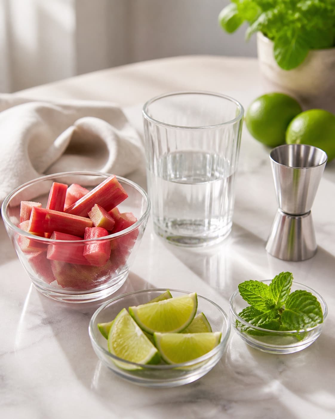One single photorealistic instructional frame of measured drink components arranged separately for Rabarber Mojito, featuring rabarber, hvid rom, lime, with only the named equipment and no unrelated food, text, logos or packaging under tilberedningen af rabarber mojito