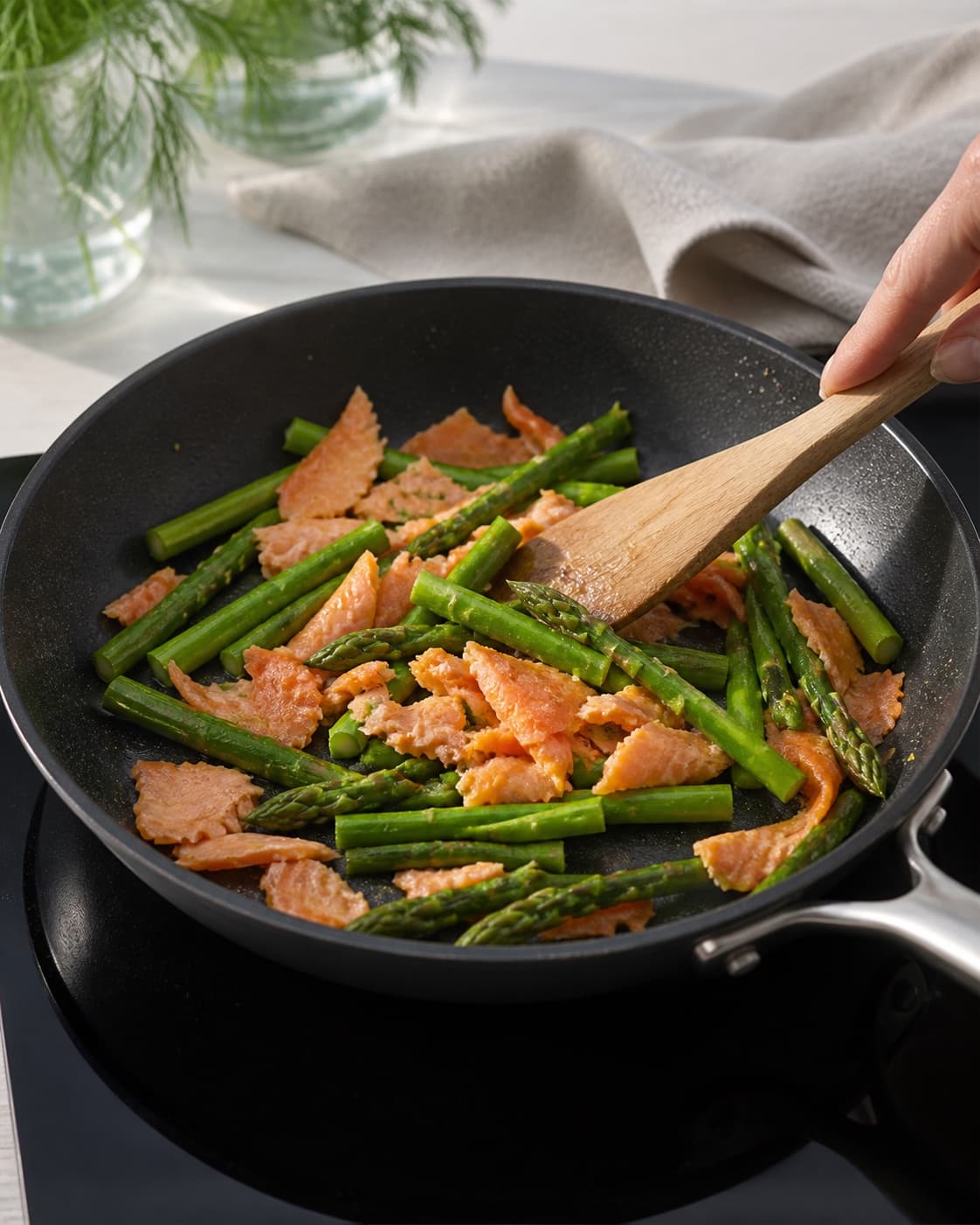 One single photorealistic instructional frame of the filling cooking until tender and dry in one skillet for Æg bagt med laks og asparges, featuring æg, varmrøget laks, grønne asparges, with only the named equipment and no unrelated food, text, logos or packaging under tilberedningen af æg bagt med laks og asparges