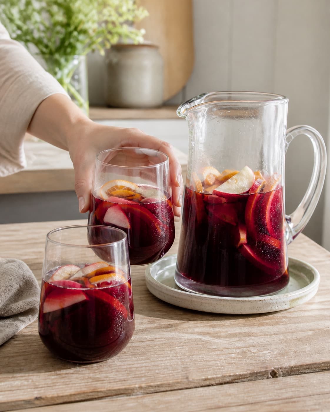 One single photorealistic instructional frame of the completed drink in clean chilled glasses with restrained garnish for Sangria, featuring rødvin, appelsin, æble, with only the named equipment and no unrelated food, text, logos or packaging under tilberedningen af sangria
