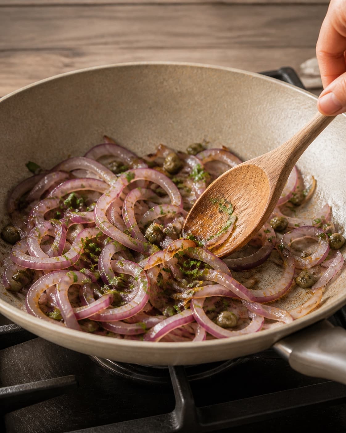 One single photorealistic instructional frame of the main robust ingredient roasting until tender and lightly browned for Løgsalat, featuring rødløg, bredbladet persille, kapers, with only the named equipment and no unrelated food, text, logos or packaging under tilberedningen af løgsalat