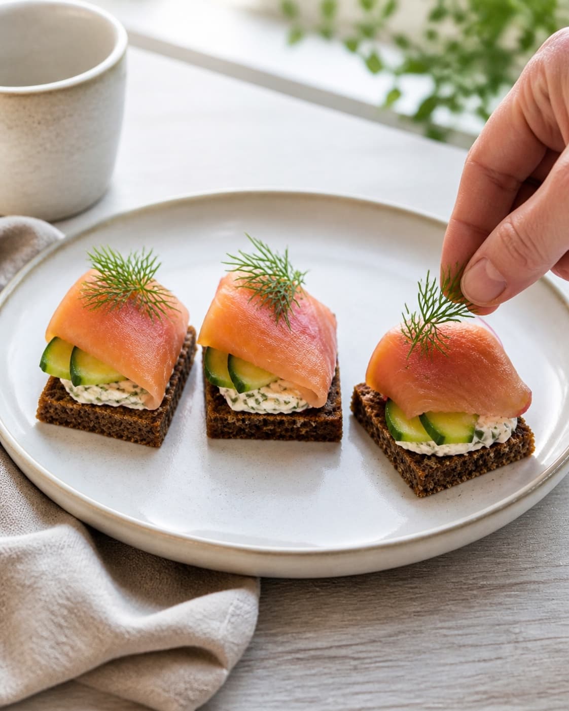 One single photorealistic instructional frame of three finished bite-size appetizers on one platter for 3 nemme hapsere, featuring rugbrød, varmrøget laks, flødeost, with only the named equipment and no unrelated food, text, logos or packaging under tilberedningen af 3 nemme hapsere