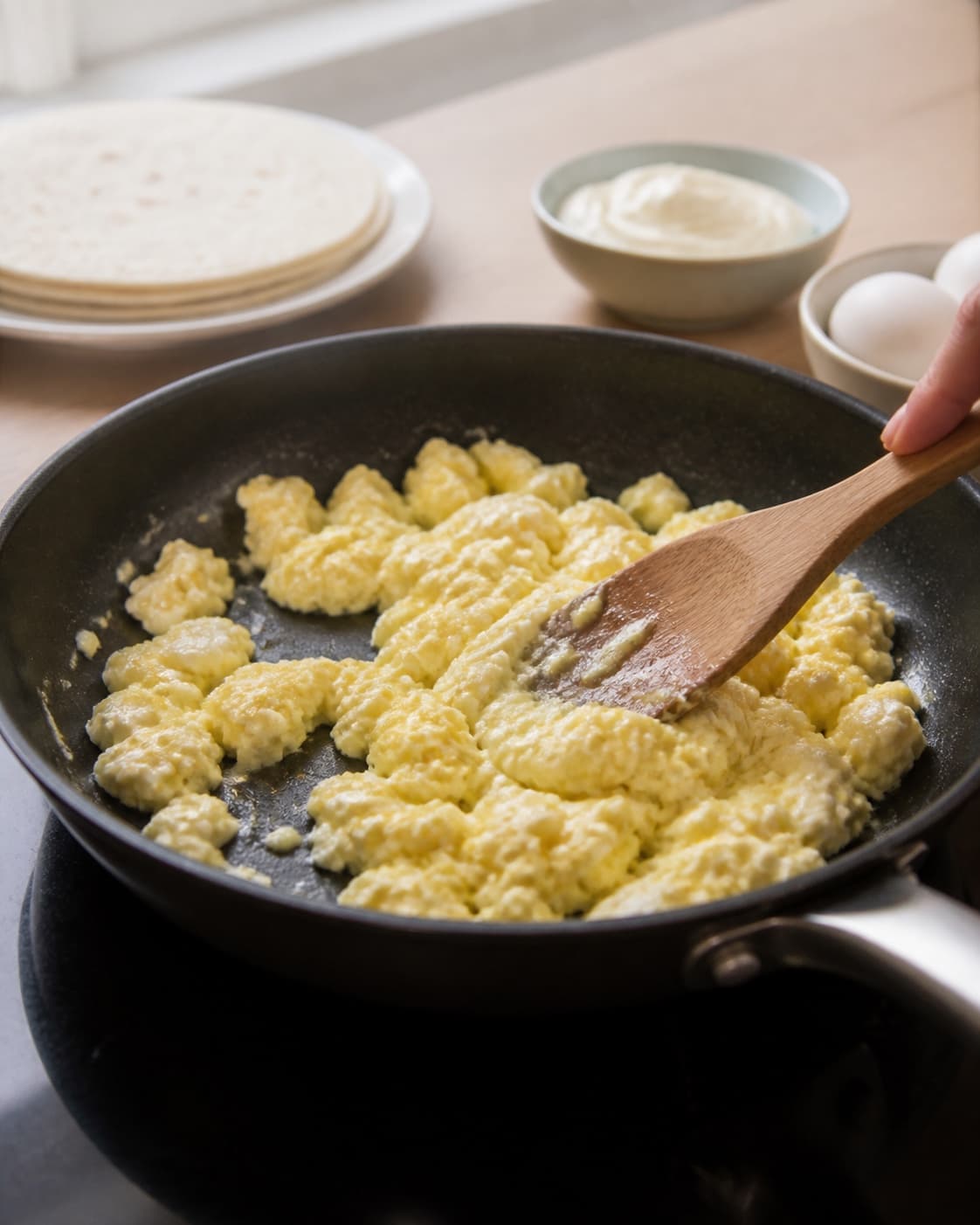 One single photorealistic instructional frame of the warm wrap filling cooking in one skillet for Wraps med æggesalat, featuring tortillawraps, æg, mayonnaise, with only the named equipment and no unrelated food, text, logos or packaging under tilberedningen af wraps med æggesalat