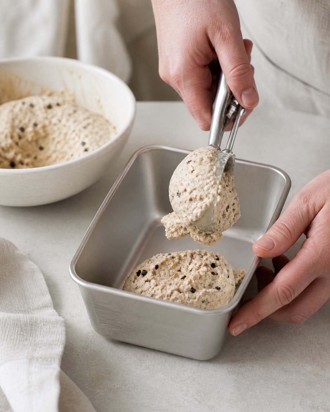 One single photorealistic instructional frame of freshly churned ice cream transferred to one container for Lakrids Flødeis, featuring piskefløde, sødmælk, æggeblommer, with only the named equipment and no unrelated food, text, logos or packaging under tilberedningen af lakrids flødeis