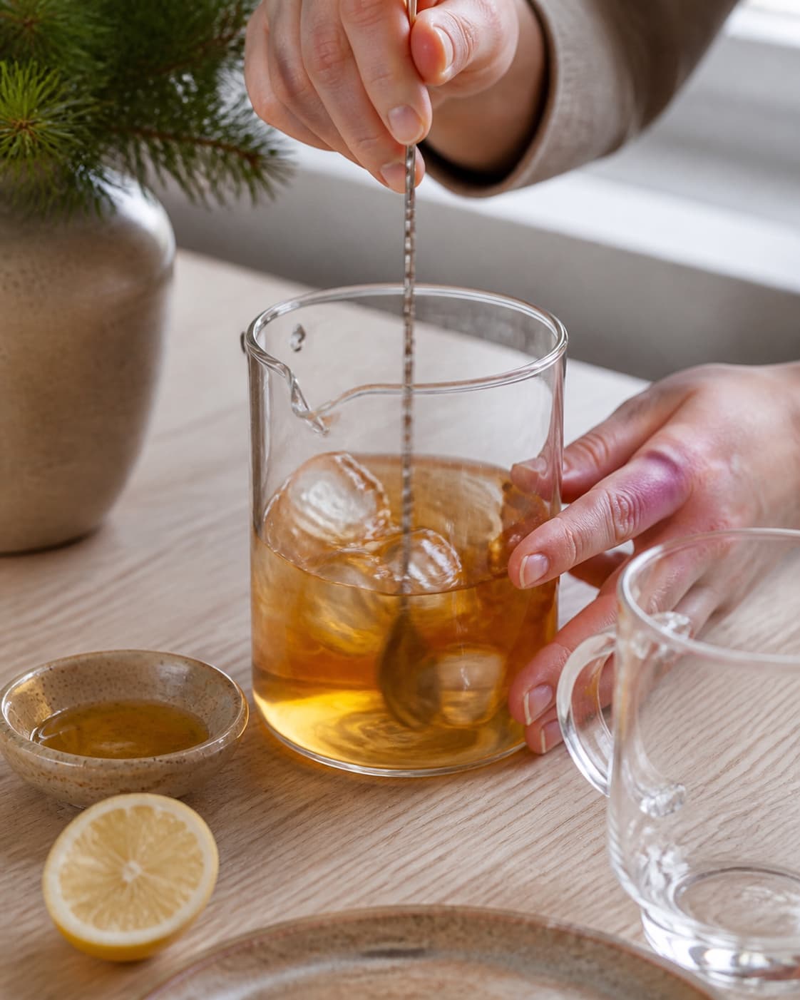One single photorealistic instructional frame of the drink being shaken or stirred with clear ice for Romtoddy, featuring mørk rom, citron, honning, with only the named equipment and no unrelated food, text, logos or packaging under tilberedningen af romtoddy