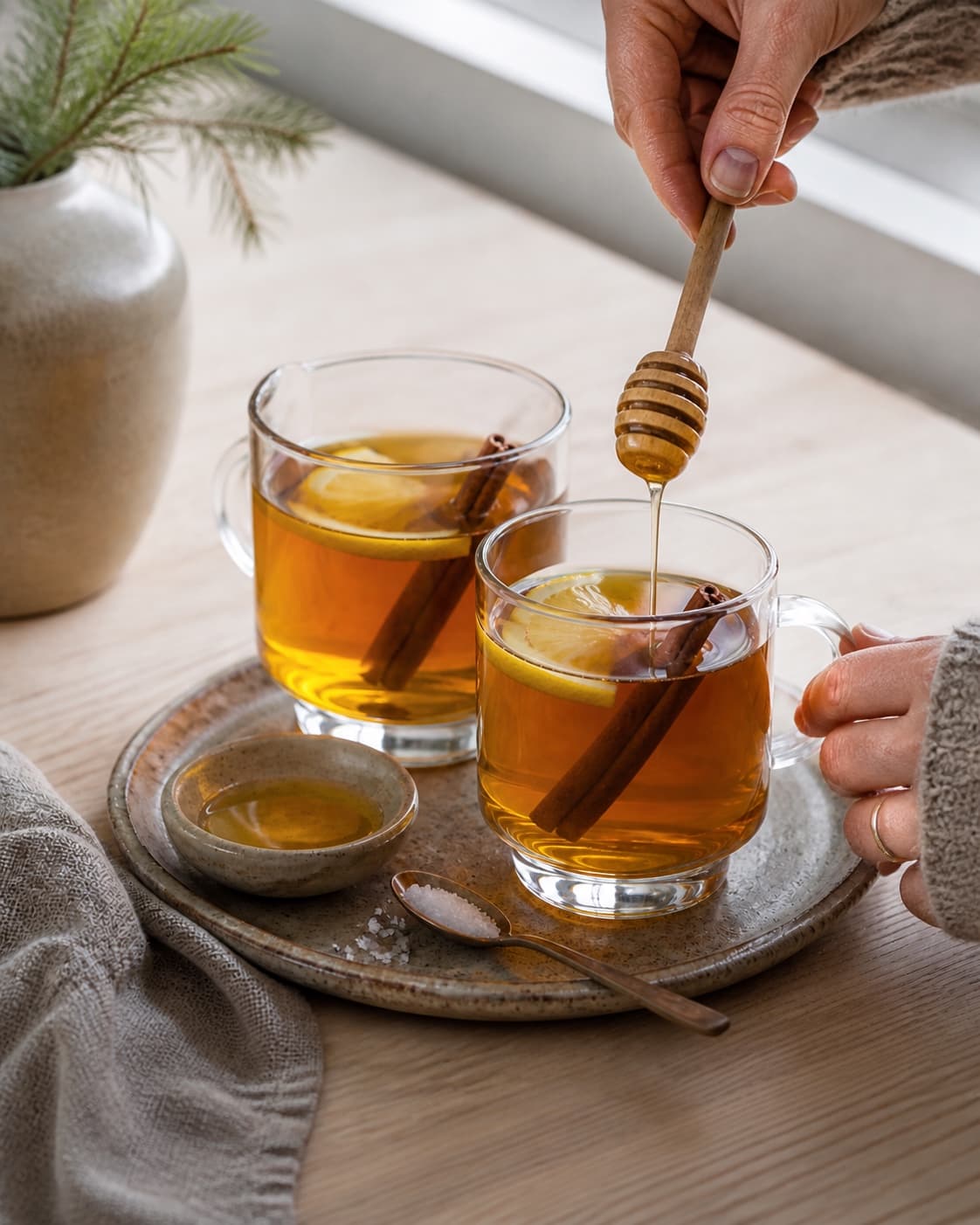 One single photorealistic instructional frame of the completed drink in clean chilled glasses with restrained garnish for Romtoddy, featuring mørk rom, citron, honning, with only the named equipment and no unrelated food, text, logos or packaging under tilberedningen af romtoddy