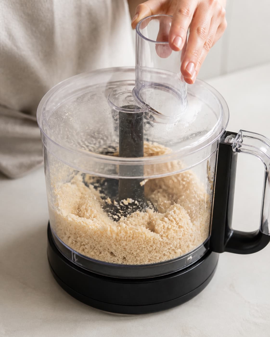 One single photorealistic instructional frame of the confection base becoming cohesive in one food processor for Hjemmelavet twix, featuring hvedemel, smør, sukker, with only the named equipment and no unrelated food, text, logos or packaging under tilberedningen af hjemmelavet twix