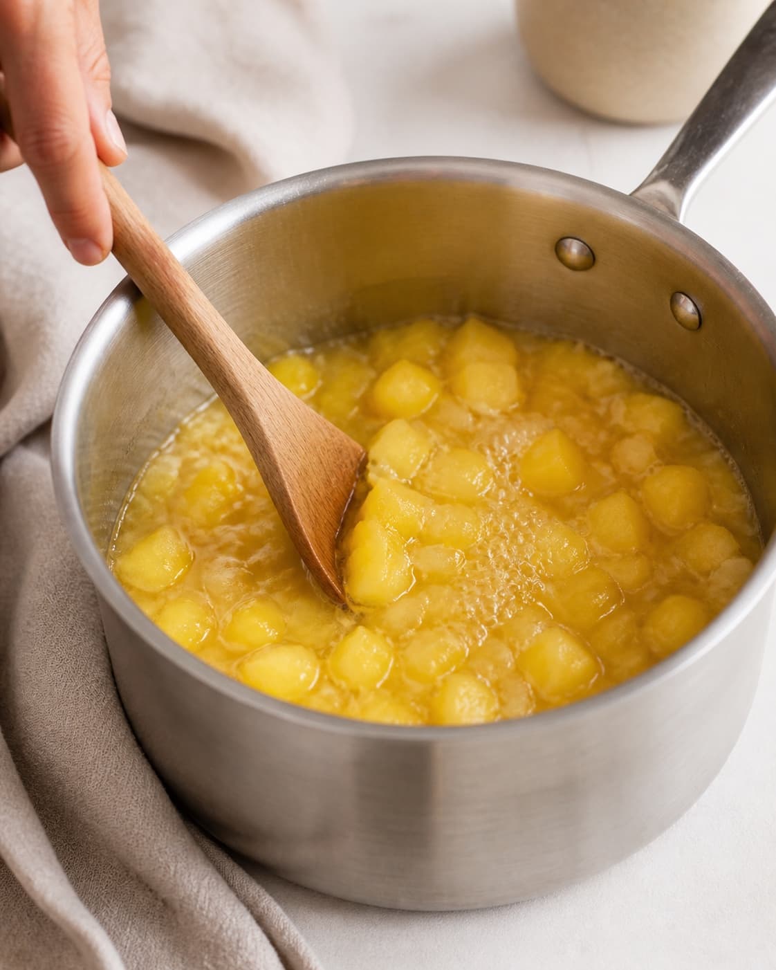 One single photorealistic instructional frame of the sauce base simmering in one saucepan for Mango Chutney, featuring mango, løg, æblecidereddike, with only the named equipment and no unrelated food, text, logos or packaging under tilberedningen af mango chutney
