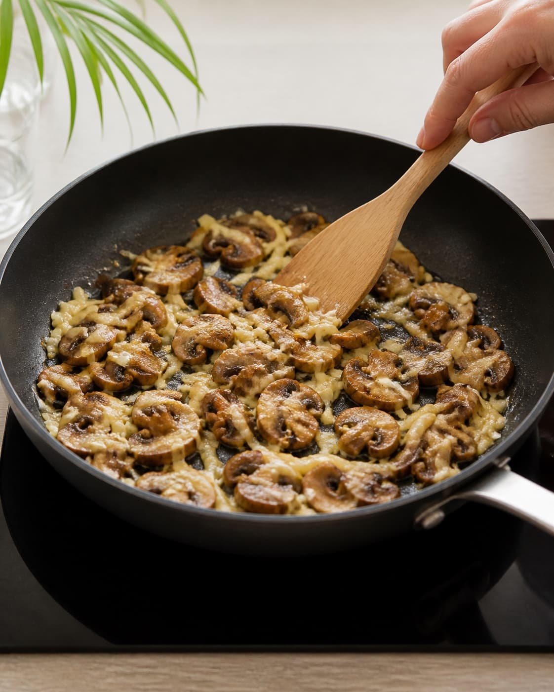 One single photorealistic instructional frame of the filling cooking until tender and dry in one skillet for Omelet med svampe og ost, featuring æg, champignon, revet ost, with only the named equipment and no unrelated food, text, logos or packaging under tilberedningen af omelet med svampe og ost