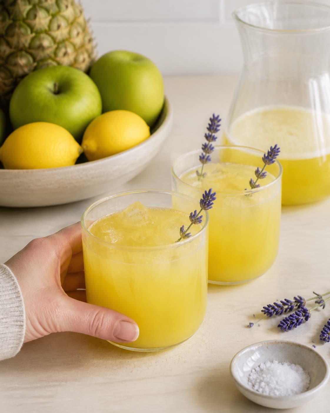 One single photorealistic instructional frame of the finished bright juice in clean chilled glasses for Ananas Lavendel Juice, featuring ananas, æbler, citron, with only the named equipment and no unrelated food, text, logos or packaging under tilberedningen af ananas lavendel juice