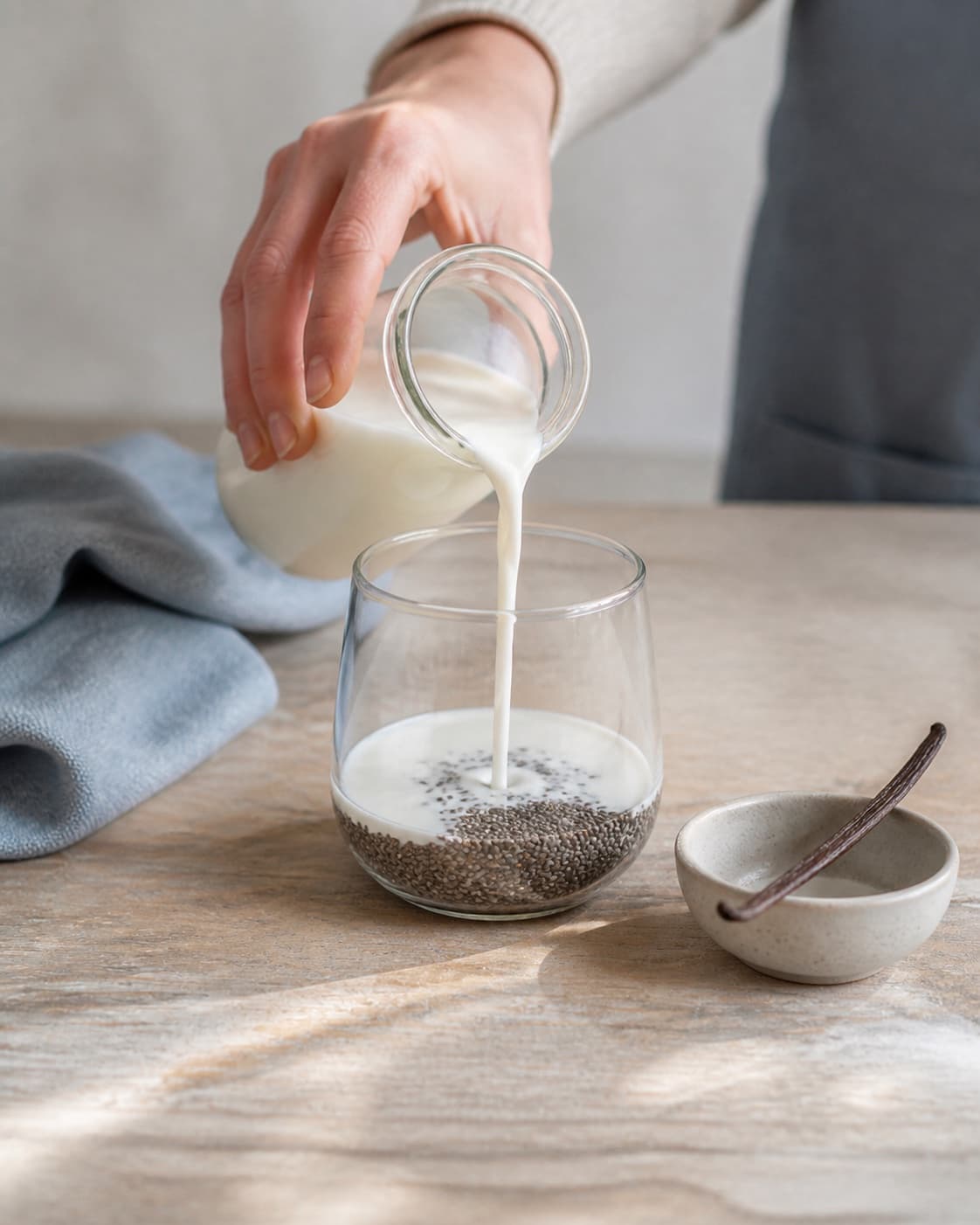 One single photorealistic instructional frame of measured grains seeds and liquid before cooking for Chiagrød, featuring chiafrø, mælk, vanilje, with only the named equipment and no unrelated food, text, logos or packaging under tilberedningen af chiagrød