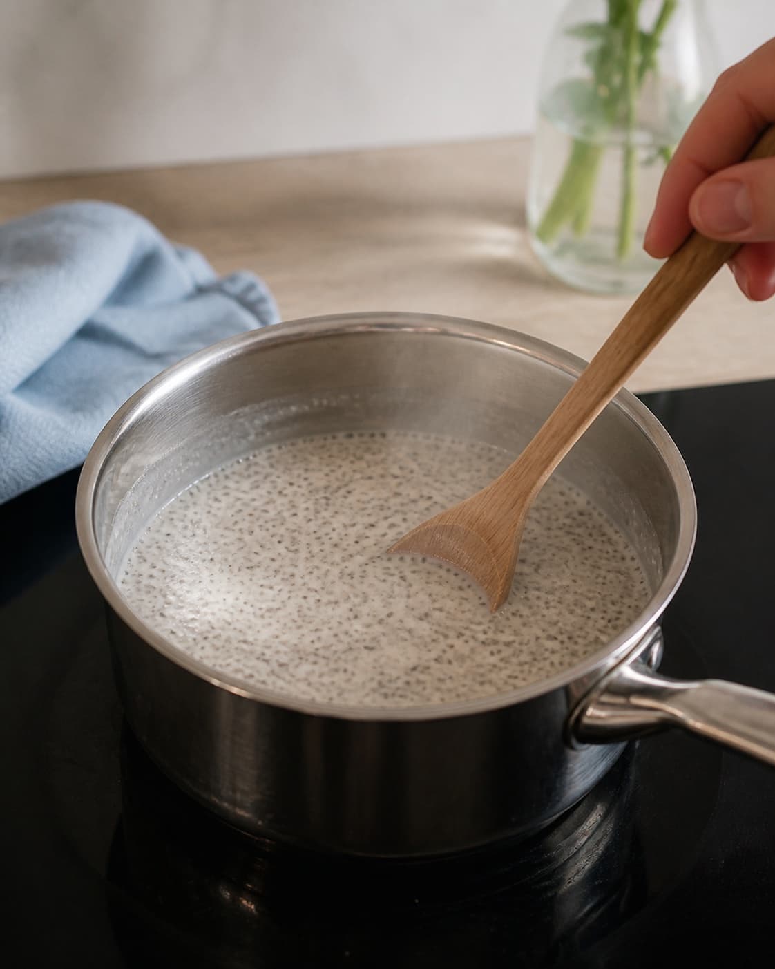 One single photorealistic instructional frame of creamy breakfast porridge gently simmering in one pot for Chiagrød, featuring chiafrø, mælk, vanilje, with only the named equipment and no unrelated food, text, logos or packaging under tilberedningen af chiagrød