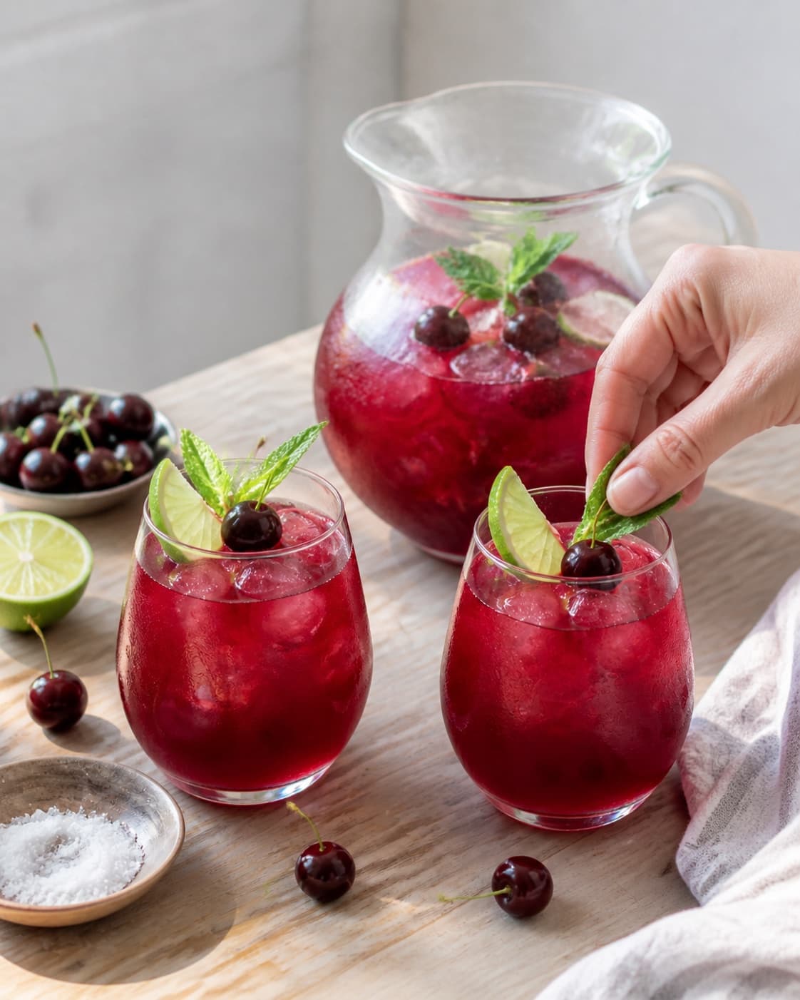 One single photorealistic instructional frame of the finished bright juice in clean chilled glasses for Kirsebærsaft, featuring kirsebær, lime, sukker, with only the named equipment and no unrelated food, text, logos or packaging under tilberedningen af kirsebærsaft