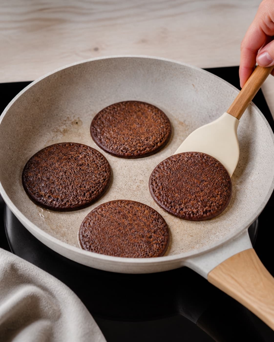 Small golden chocolate pancakes cooking in one skillet with a spatula, no saucepan or porridge under tilberedningen af chokolade pandekager