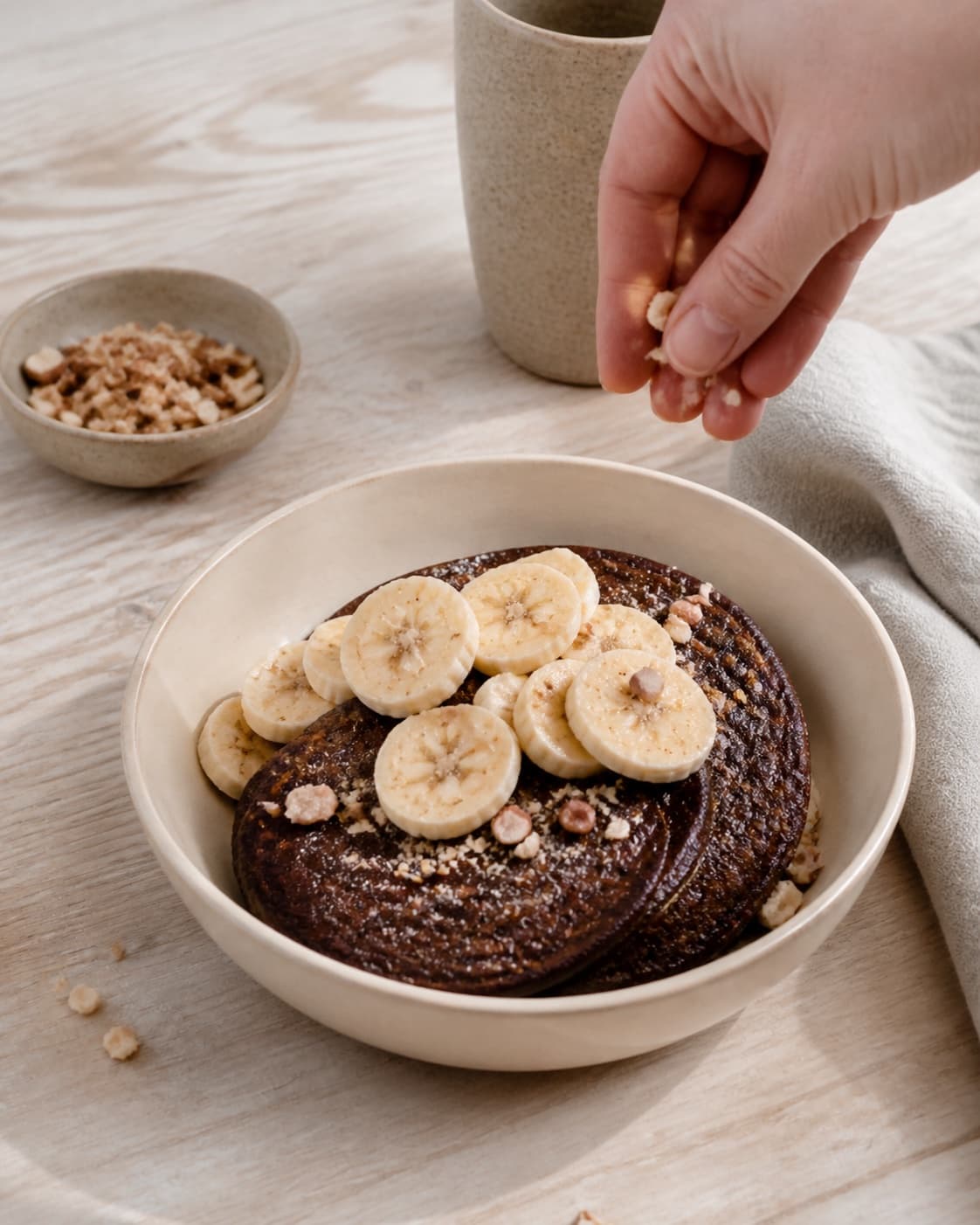 One single photorealistic instructional frame of finished breakfast bowls topped with the named fruit and garnish for Chokolade pandekager, featuring hvedemel, kakaopulver, æg, with only the named equipment and no unrelated food, text, logos or packaging under tilberedningen af chokolade pandekager
