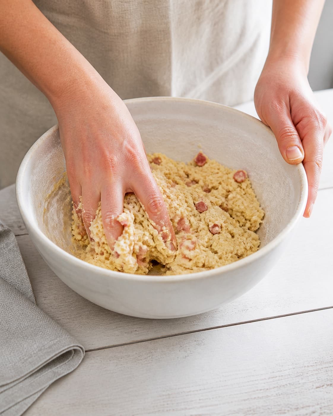 One single photorealistic instructional frame of a cohesive pastry dough being mixed in one bowl for Quiche lorraine, featuring hvedemel, smør, bacon, with only the named equipment and no unrelated food, text, logos or packaging under tilberedningen af quiche lorraine
