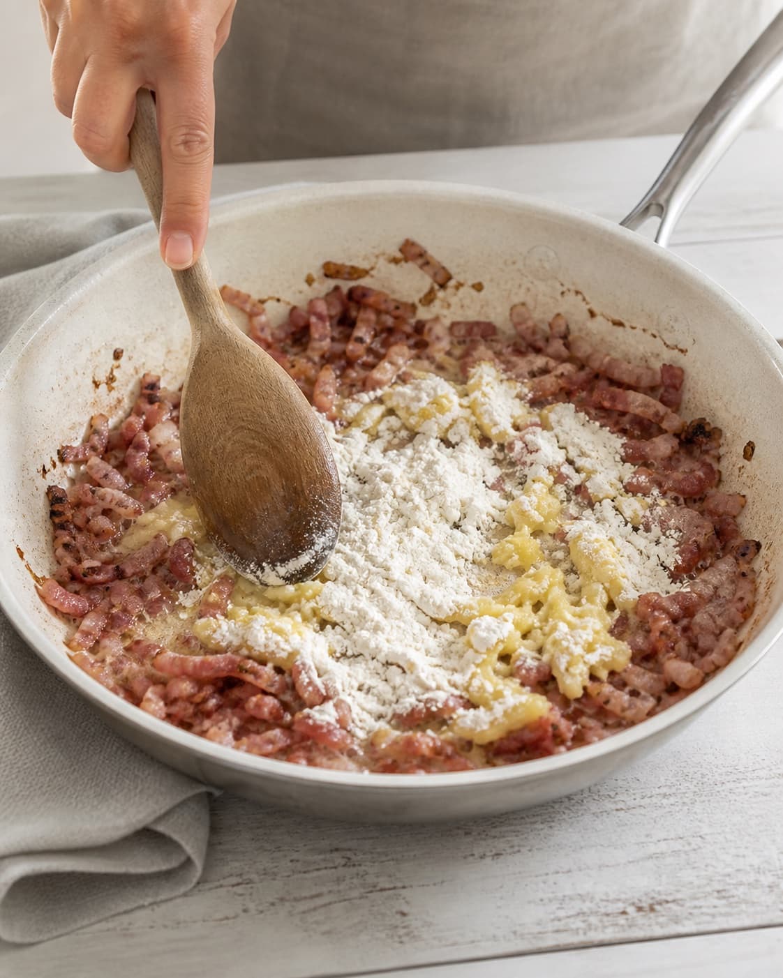One single photorealistic instructional frame of the recipe-specific filling cooked in one pan for Quiche lorraine, featuring hvedemel, smør, bacon, with only the named equipment and no unrelated food, text, logos or packaging under tilberedningen af quiche lorraine