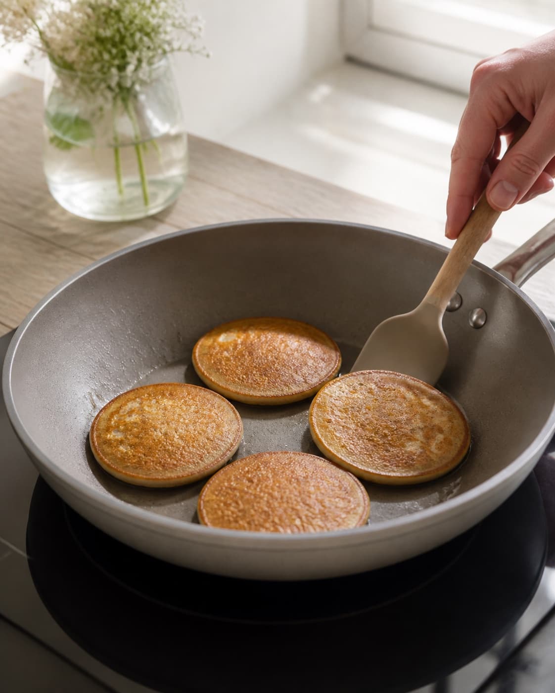 Small golden buckwheat pancakes cooking in one skillet with a spatula, no saucepan or porridge under tilberedningen af boghvedepandekager