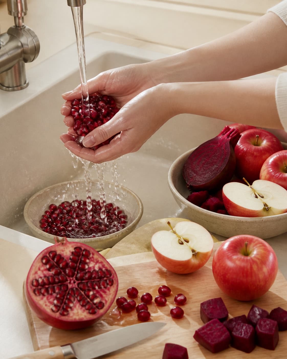 One single photorealistic instructional frame of fresh produce being washed and trimmed for Granatæble juice med power, featuring granatæblekerner, æbler, rødbede, with only the named equipment and no unrelated food, text, logos or packaging under tilberedningen af granatæble juice med power