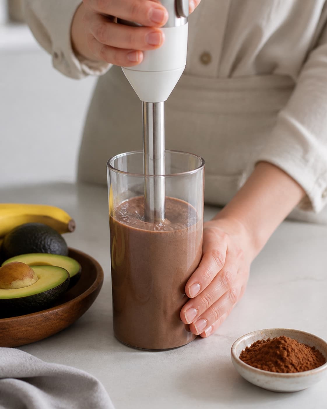 One single photorealistic instructional frame of the final colorful smoothie blending until thick and uniform for Sund Chokolade Smoothie, featuring banan, kakaopulver, avocado, with only the named equipment and no unrelated food, text, logos or packaging under tilberedningen af sund chokolade smoothie