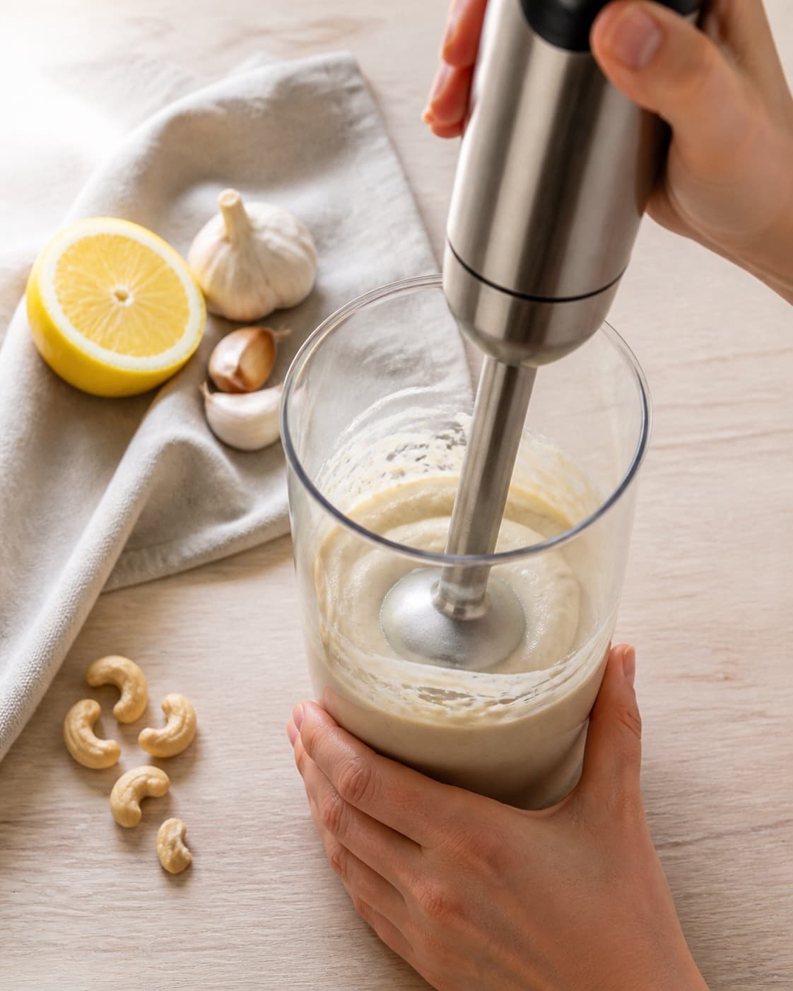 One single photorealistic instructional frame of the dip blending into a smooth cohesive texture for Cashewnød dip, featuring cashewnødder, citron, hvidløg, with only the named equipment and no unrelated food, text, logos or packaging under tilberedningen af cashewnød dip