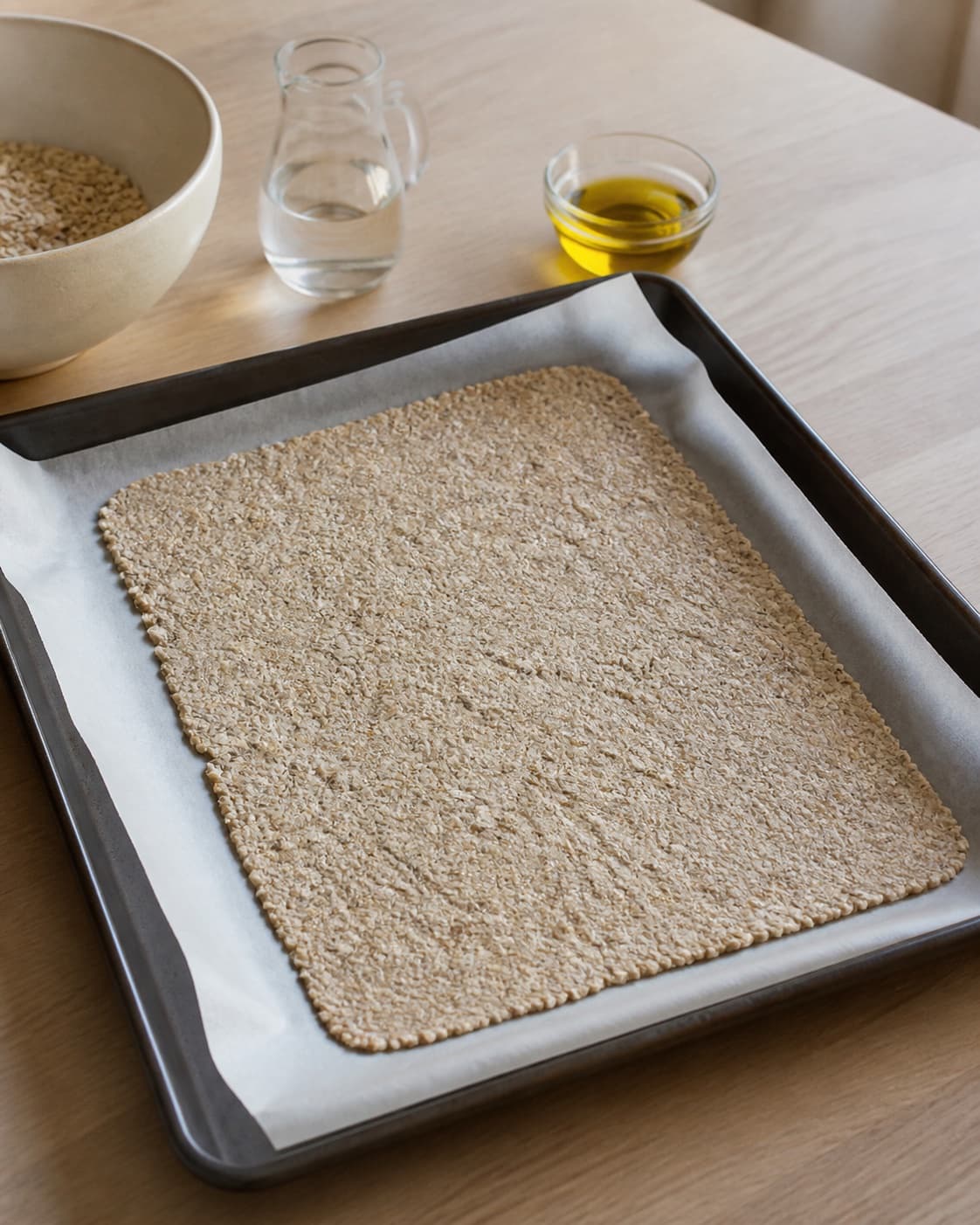 One single photorealistic instructional frame of the main ingredient trimmed cut and dried before roasting for Havregrødschips, featuring havregryn, vand, olivenolie, with only the named equipment and no unrelated food, text, logos or packaging under tilberedningen af havregrødschips