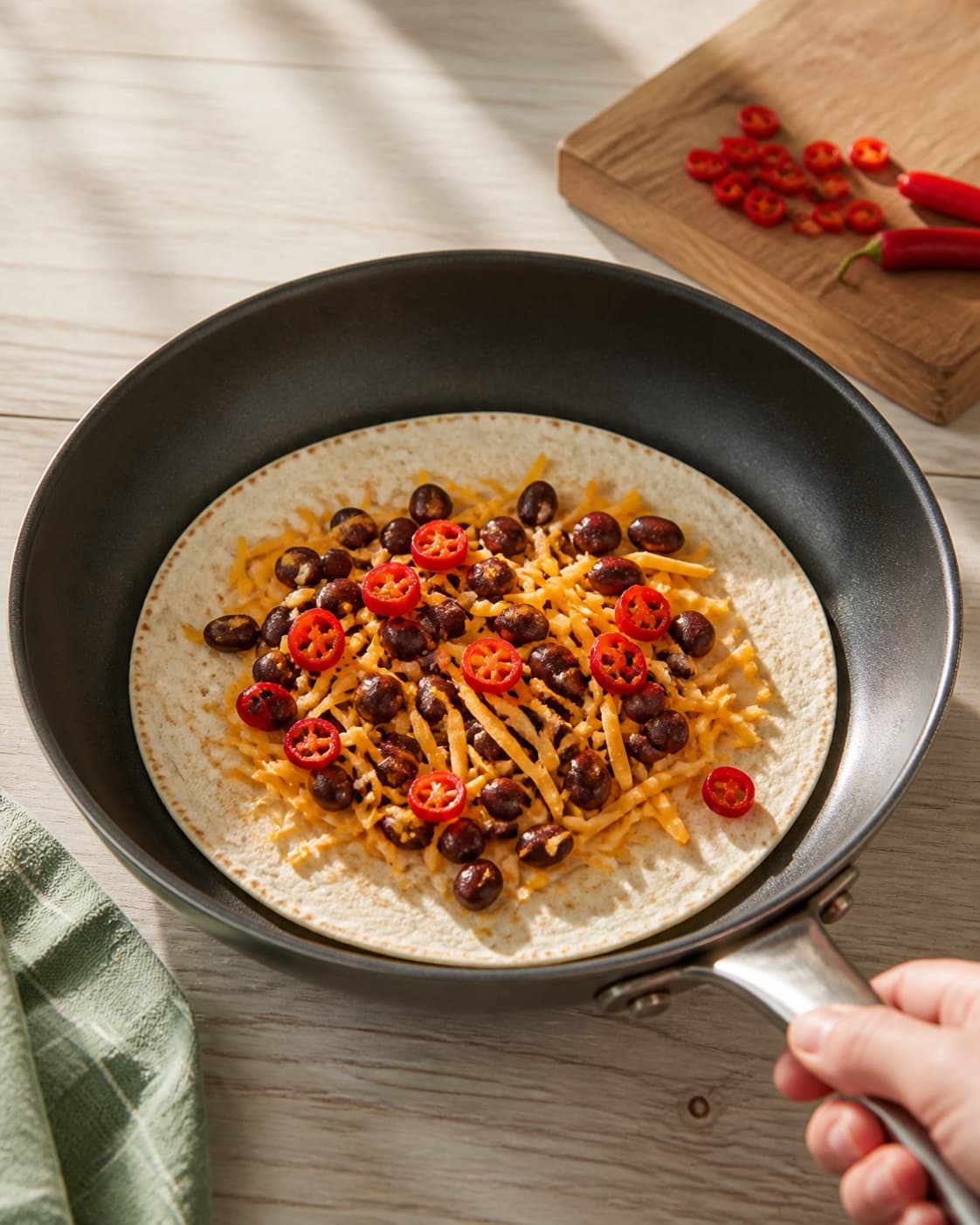One single photorealistic instructional frame of the warm wrap filling cooking in one skillet for Quesadillas med Chili, featuring tortillas, cheddar, rød chili, with only the named equipment and no unrelated food, text, logos or packaging under tilberedningen af quesadillas med chili