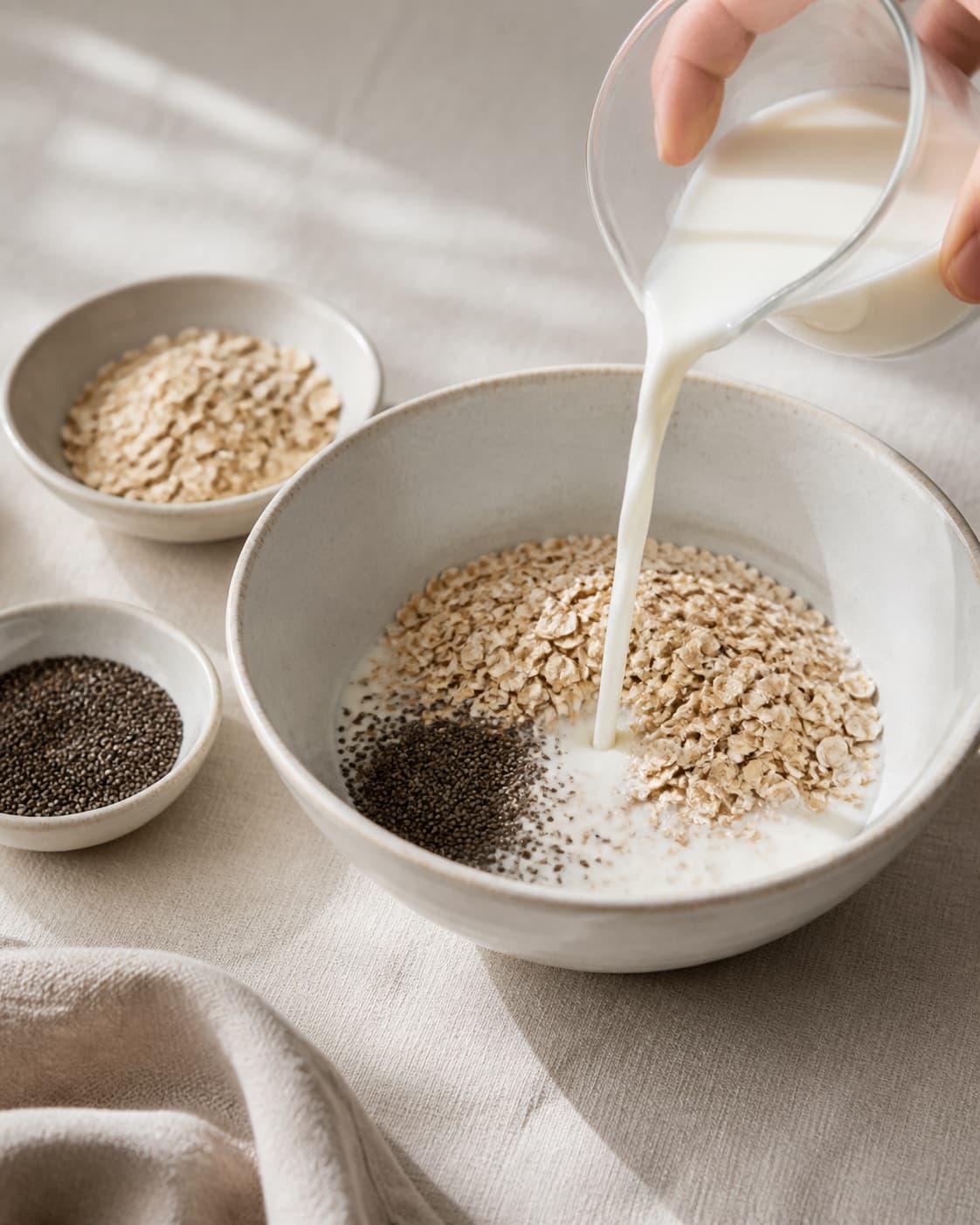 One single photorealistic instructional frame of measured grains seeds and liquid before cooking for Køleskabsgrød, featuring havregryn, mælk, chiafrø, with only the named equipment and no unrelated food, text, logos or packaging under tilberedningen af køleskabsgrød