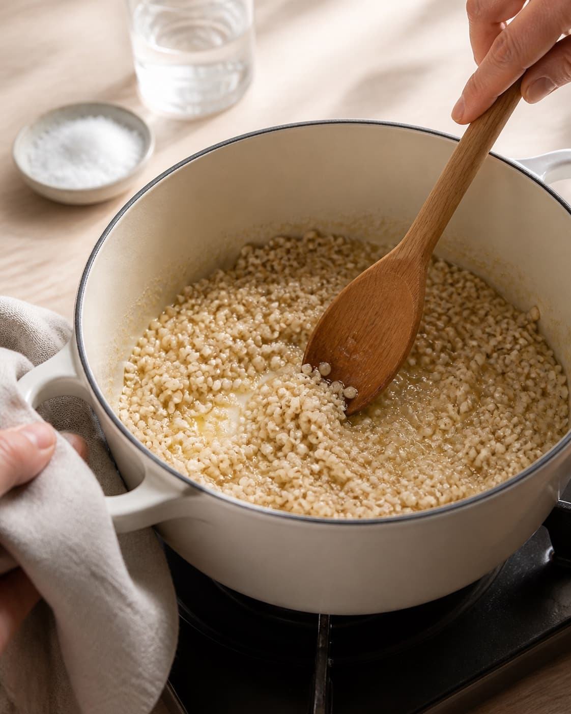 Pearl barley being toasted gently in butter in one pot, no meat cubes or browned beef under tilberedningen af bygotto med varmrøget laks
