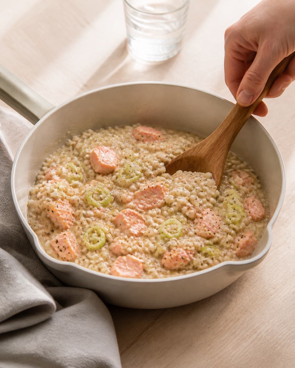 One single photorealistic instructional frame of the finished glossy stew ready in one serving pot for Bygotto med varmrøget laks, featuring perlebyg, varmrøget laks, porrer, with only the named equipment and no unrelated food, text, logos or packaging under tilberedningen af bygotto med varmrøget laks