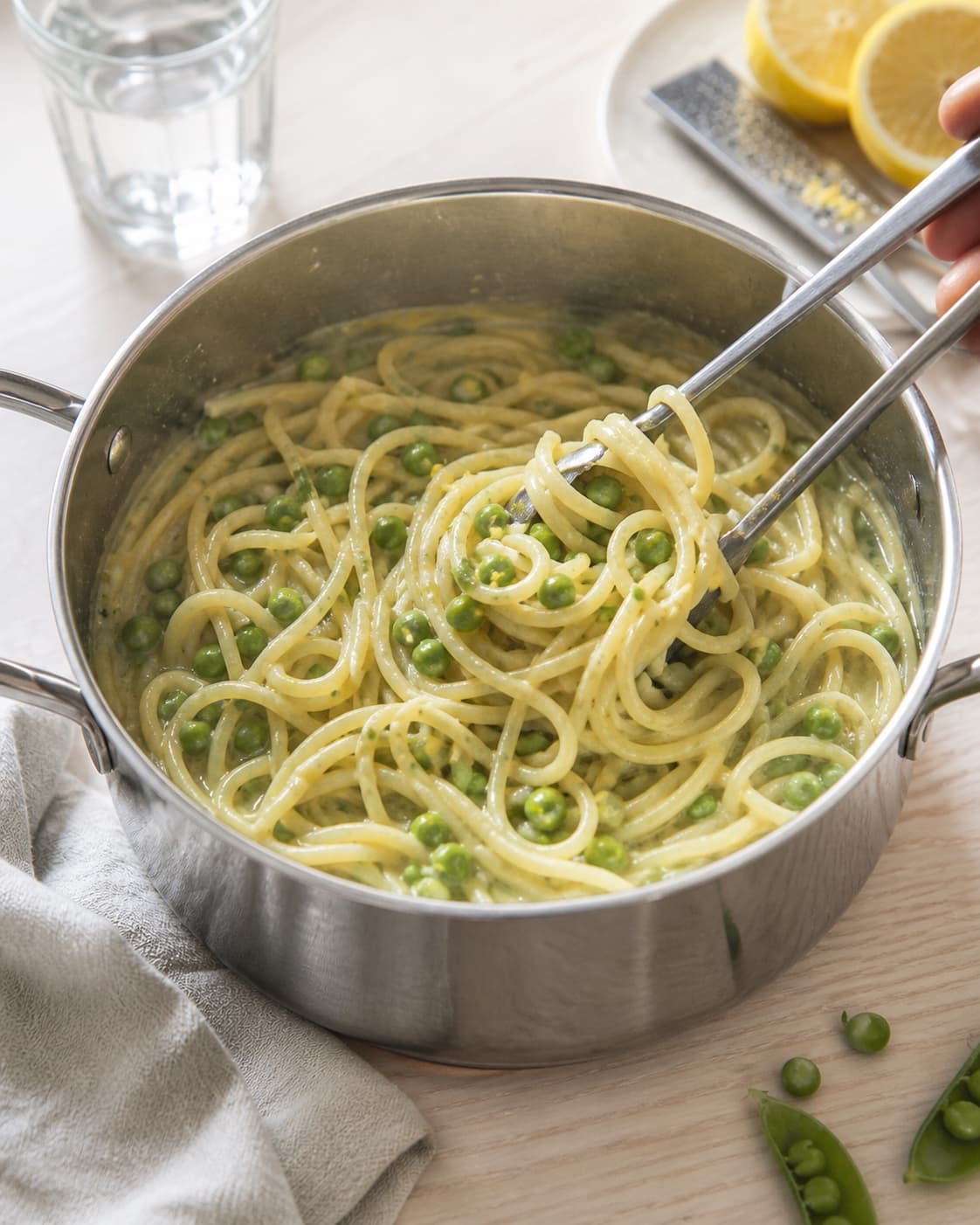One single photorealistic instructional frame of the finished glossy stew ready in one serving pot for Pasta med ærter og citron, featuring pasta, grønne ærter, citron, with only the named equipment and no unrelated food, text, logos or packaging under tilberedningen af pasta med ærter og citron
