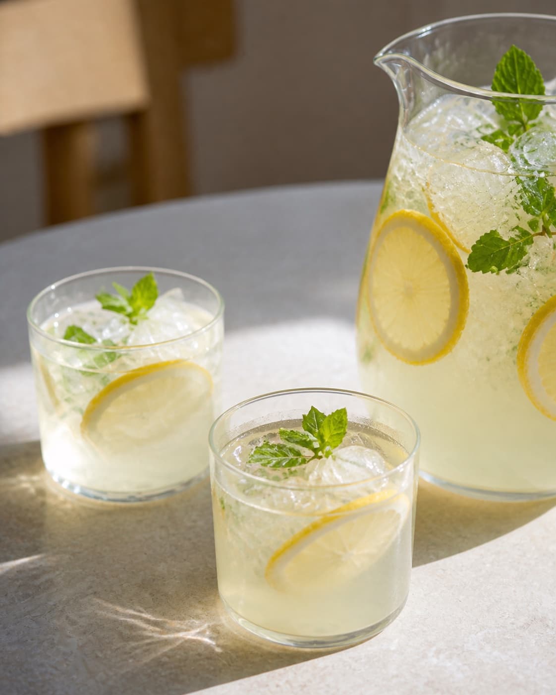 One single photorealistic instructional frame of the completed drink in clean chilled glasses with restrained garnish for Lemonade, featuring citron, sukker, vand, with only the named equipment and no unrelated food, text, logos or packaging under tilberedningen af lemonade