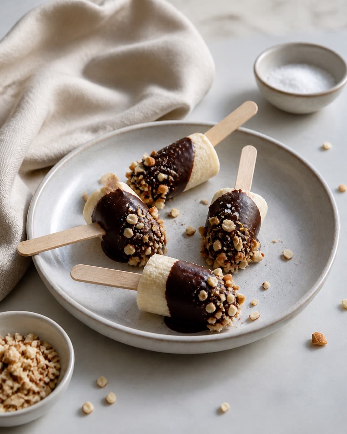 Finished chocolate-coated frozen banana ice pops on wooden sticks, no ice-cream tub under tilberedningen af bananis af frosne bananstykker