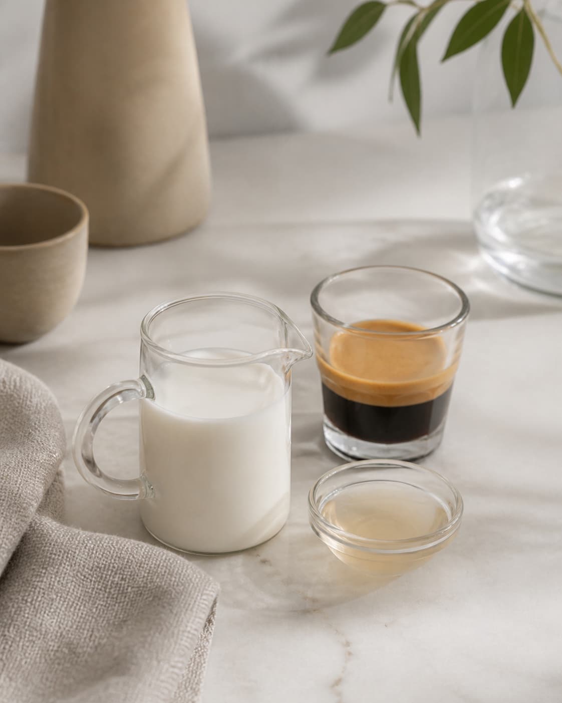 One single photorealistic instructional frame of measured drink components arranged separately for Iced Dolce Latte, featuring espresso, mælk, vaniljesirup, with only the named equipment and no unrelated food, text, logos or packaging under tilberedningen af iced dolce latte