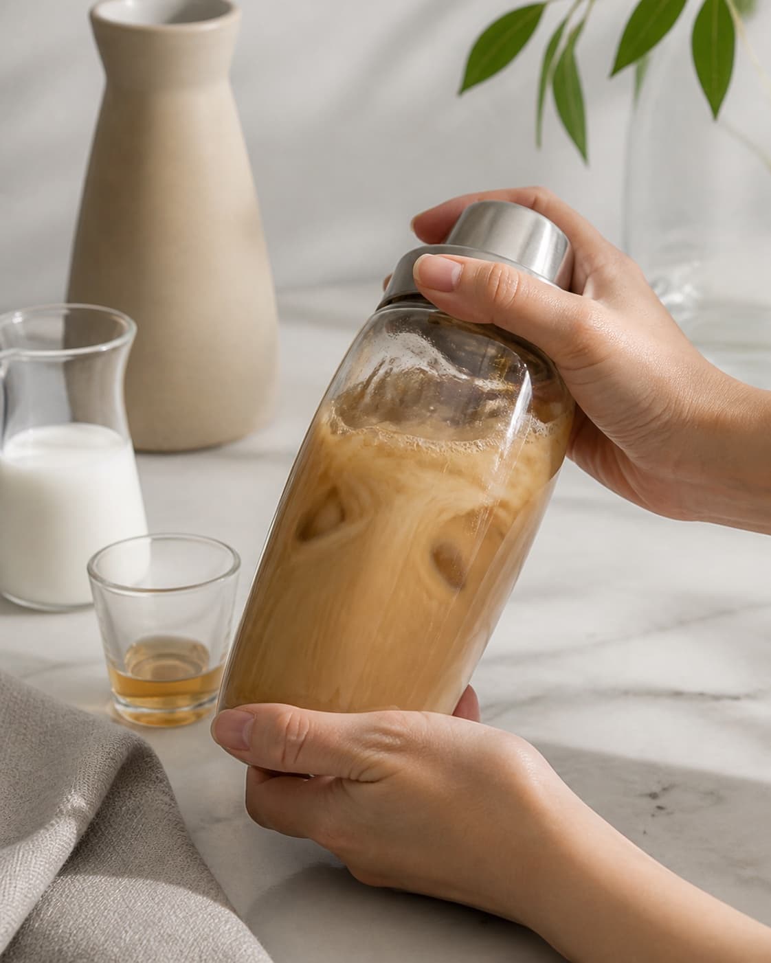 One single photorealistic instructional frame of the drink being shaken or stirred with clear ice for Iced Dolce Latte, featuring espresso, mælk, vaniljesirup, with only the named equipment and no unrelated food, text, logos or packaging under tilberedningen af iced dolce latte
