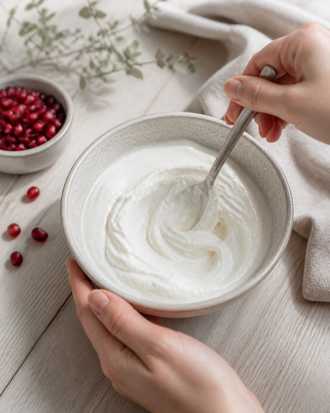 Cold thick skyr being stirred creamy in one bowl, no saucepan, stove, steam or porridge under tilberedningen af morgenmad med skyr og granatæble