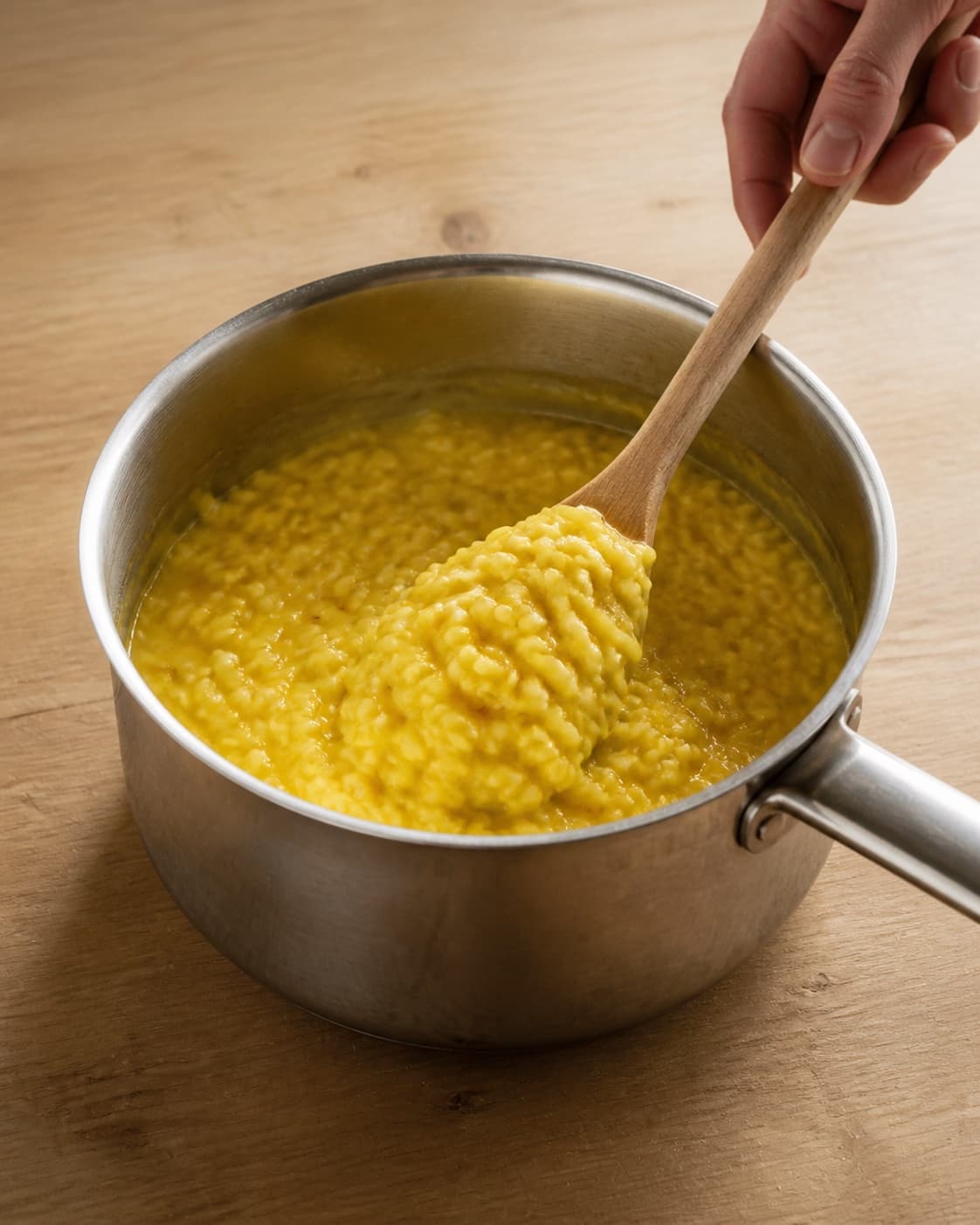 One single photorealistic instructional frame of the finished glossy stew ready in one serving pot for Safranrisotto, featuring risottoris, safran, grøntsagsfond, with only the named equipment and no unrelated food, text, logos or packaging under tilberedningen af safranrisotto